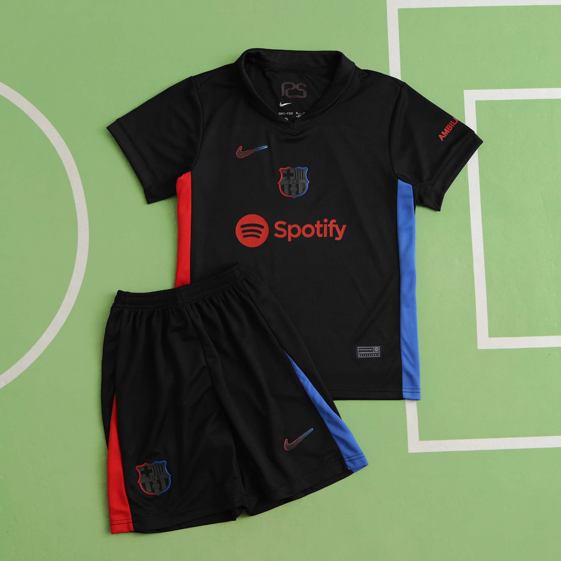 Black soccer jersey and shorts with red, blue, and gray accents, displaying the FC Barcelona crest, Nike logo, and Spotify sponsorship, laid on a green sports court.