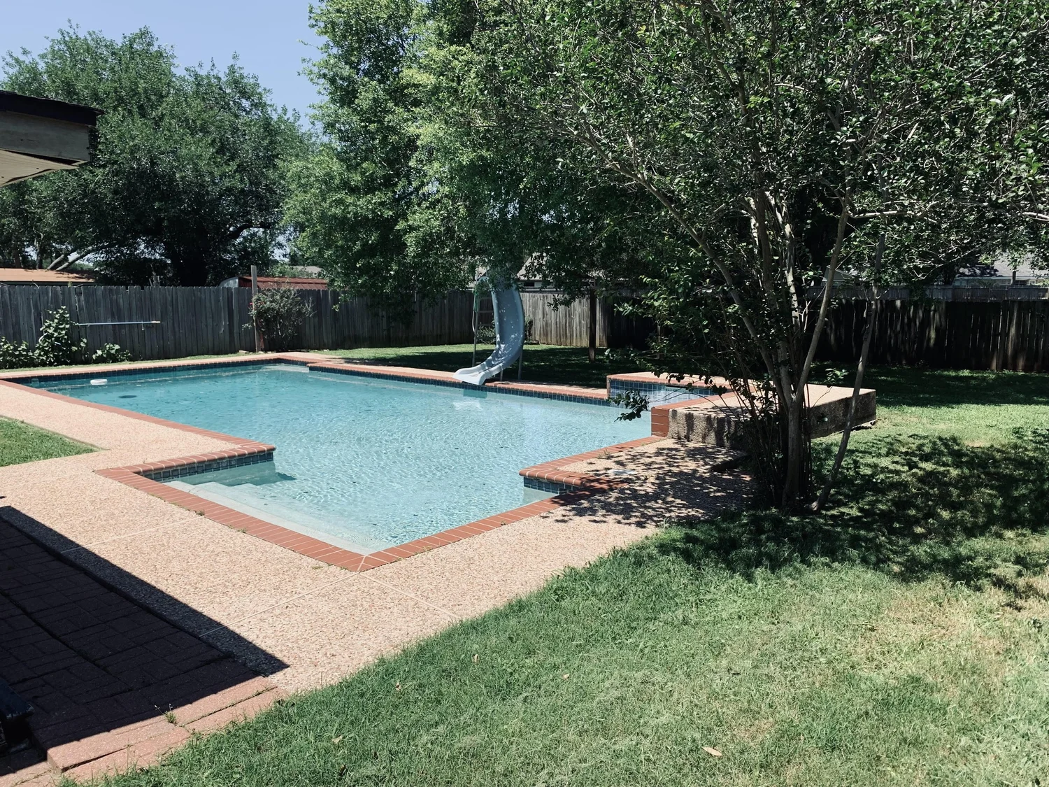 ReedMow lawn care: freshly mowed backyard lawn beside a pool in Sugar Land, TX