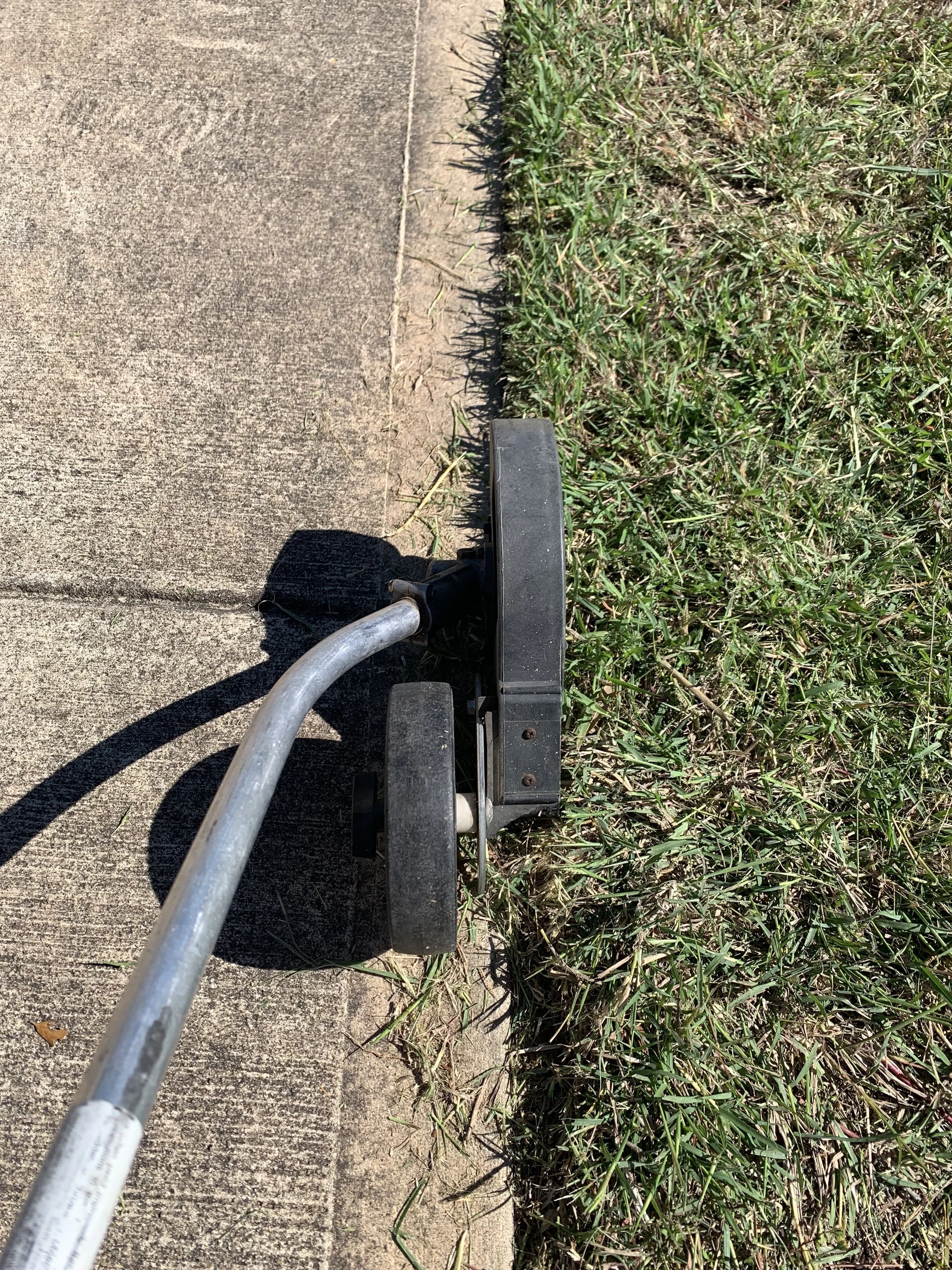 Edger creating sharp line along sidewalk in Missouri City – seamless edge trimming for well-kept lawns.