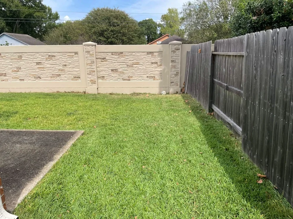 Backyard after mowing along the white brick wall