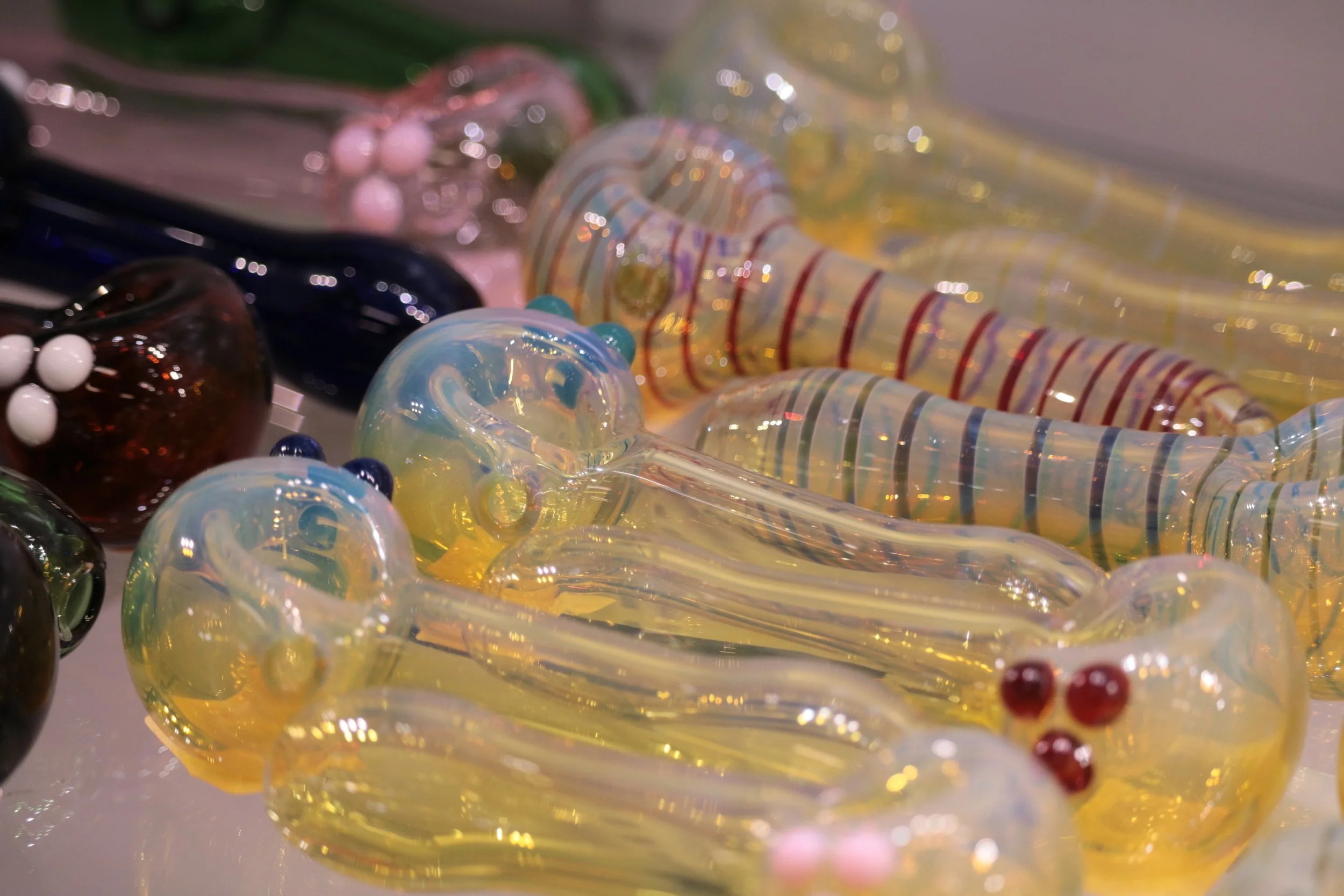 Close-up of various colorful glass handpipes