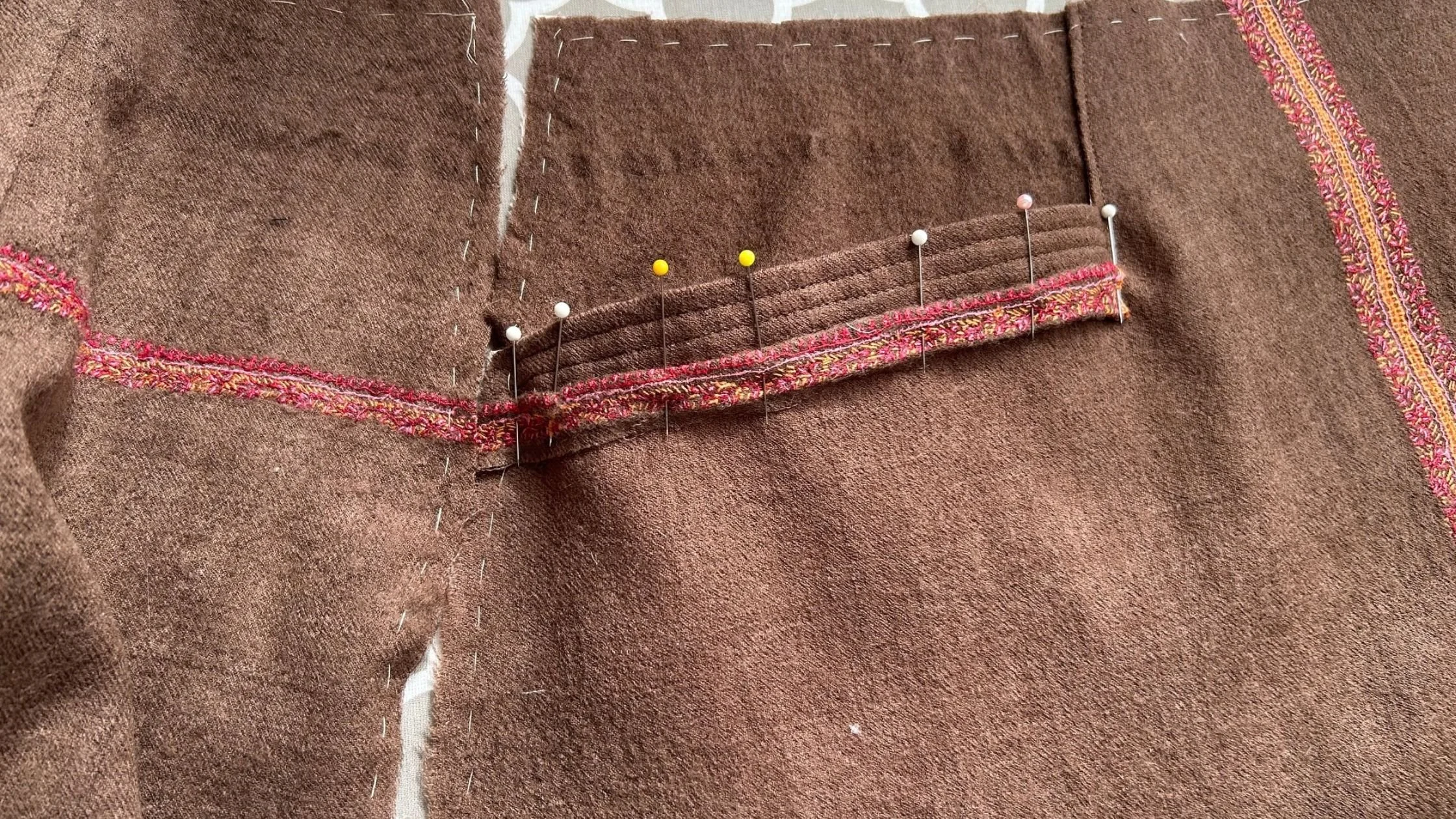 applique trim at pocket edge matched with embroidery on back side.