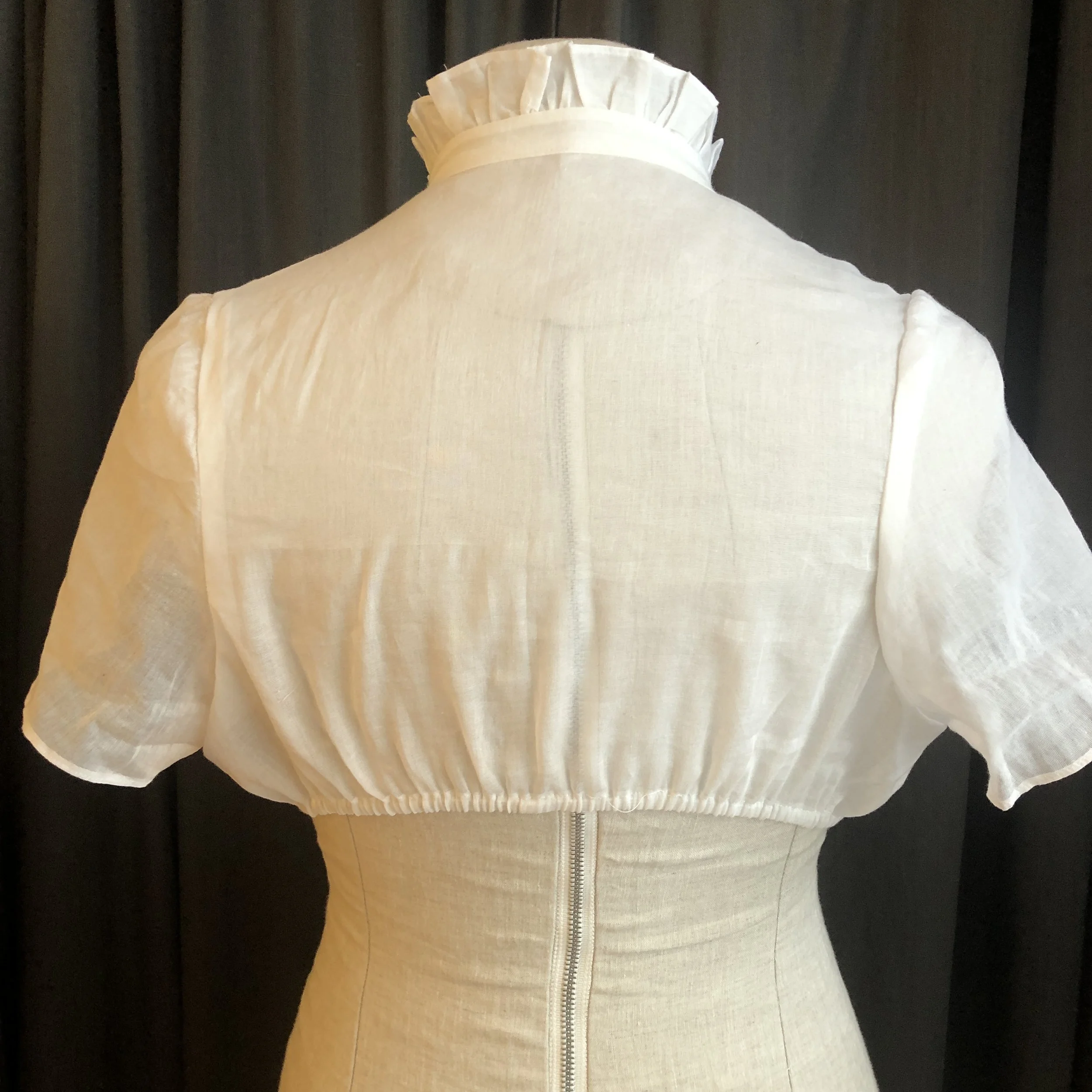 back of high neck dirndl blouse with collared neck and short flutter sleeves