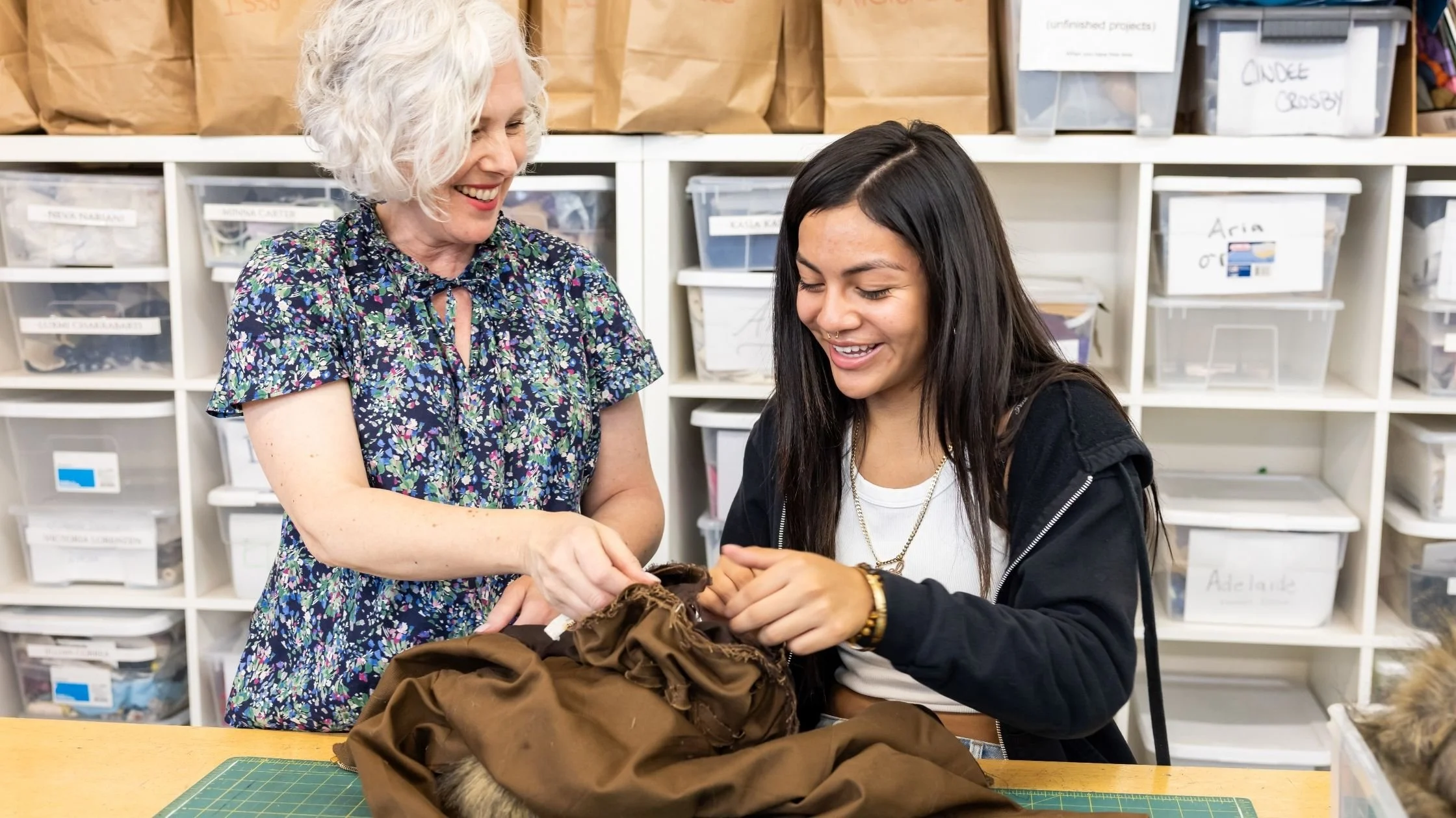 Sewing Instructor and student reviewing skills on sewing project. Two happy women discussing sewing