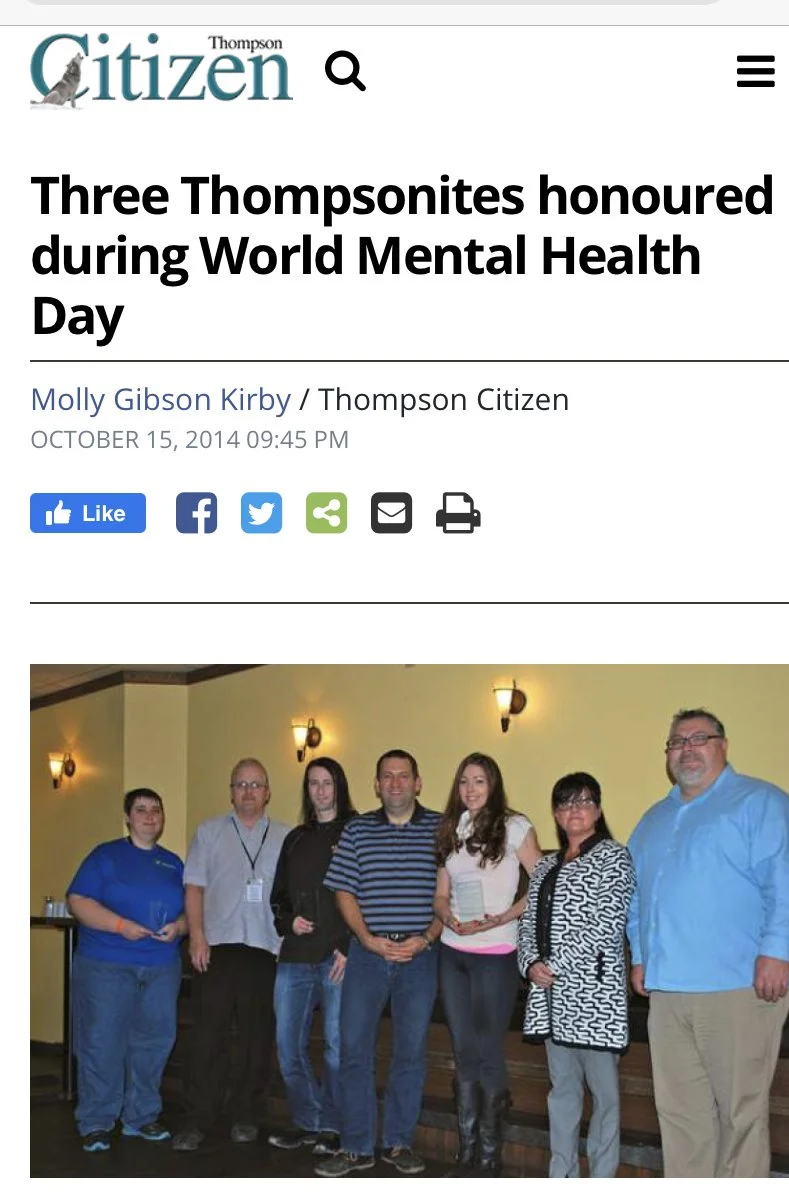 Group of seven people standing together indoors, posing for a photo during an event or award ceremony.