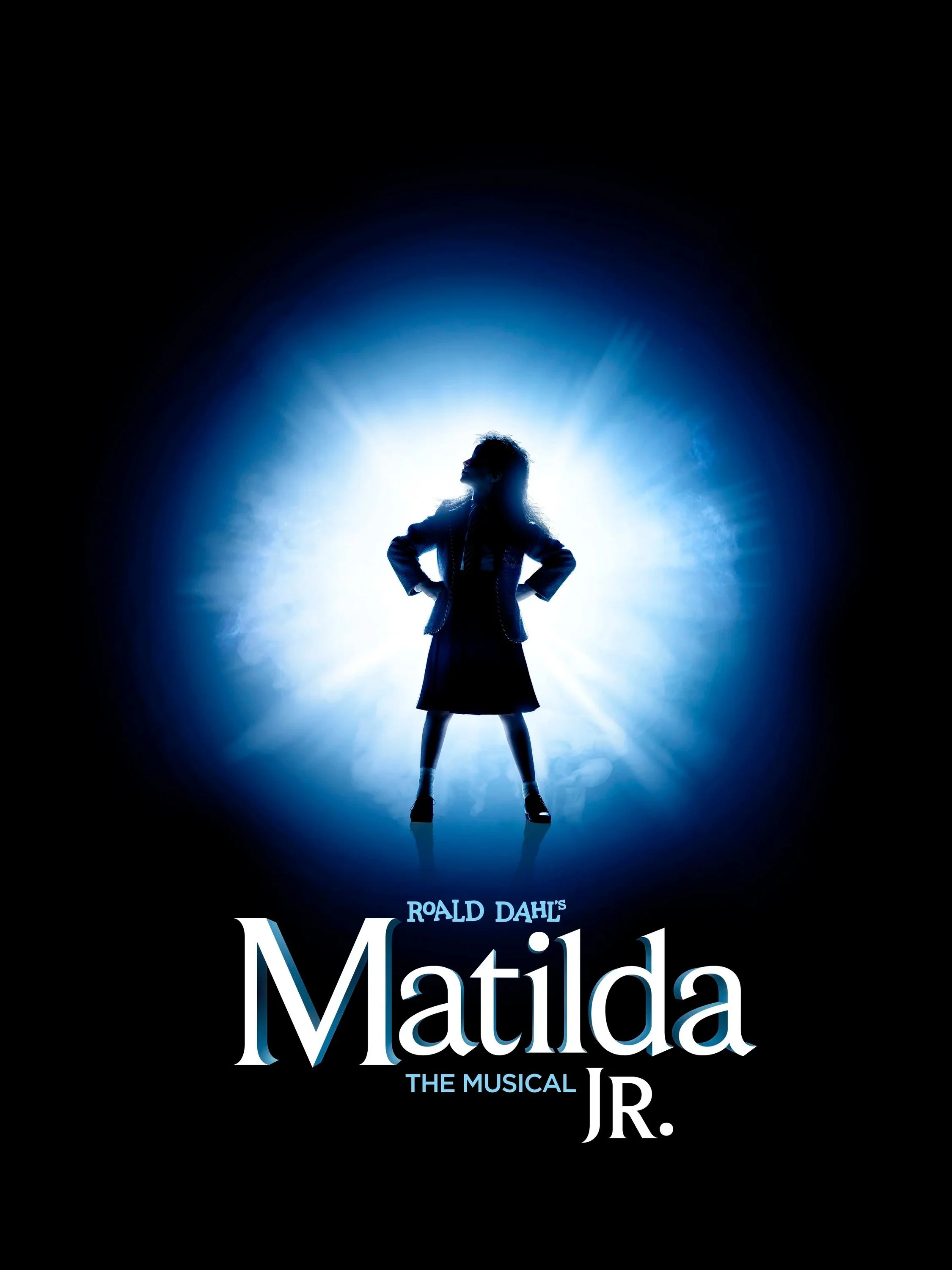 Silhouette of a young girl with hands on hips, standing confidently, backlit by a bright blue and white light in a dark background. Text at the bottom reads 'Roald Dahl's Matilda The Musical Jr.'.