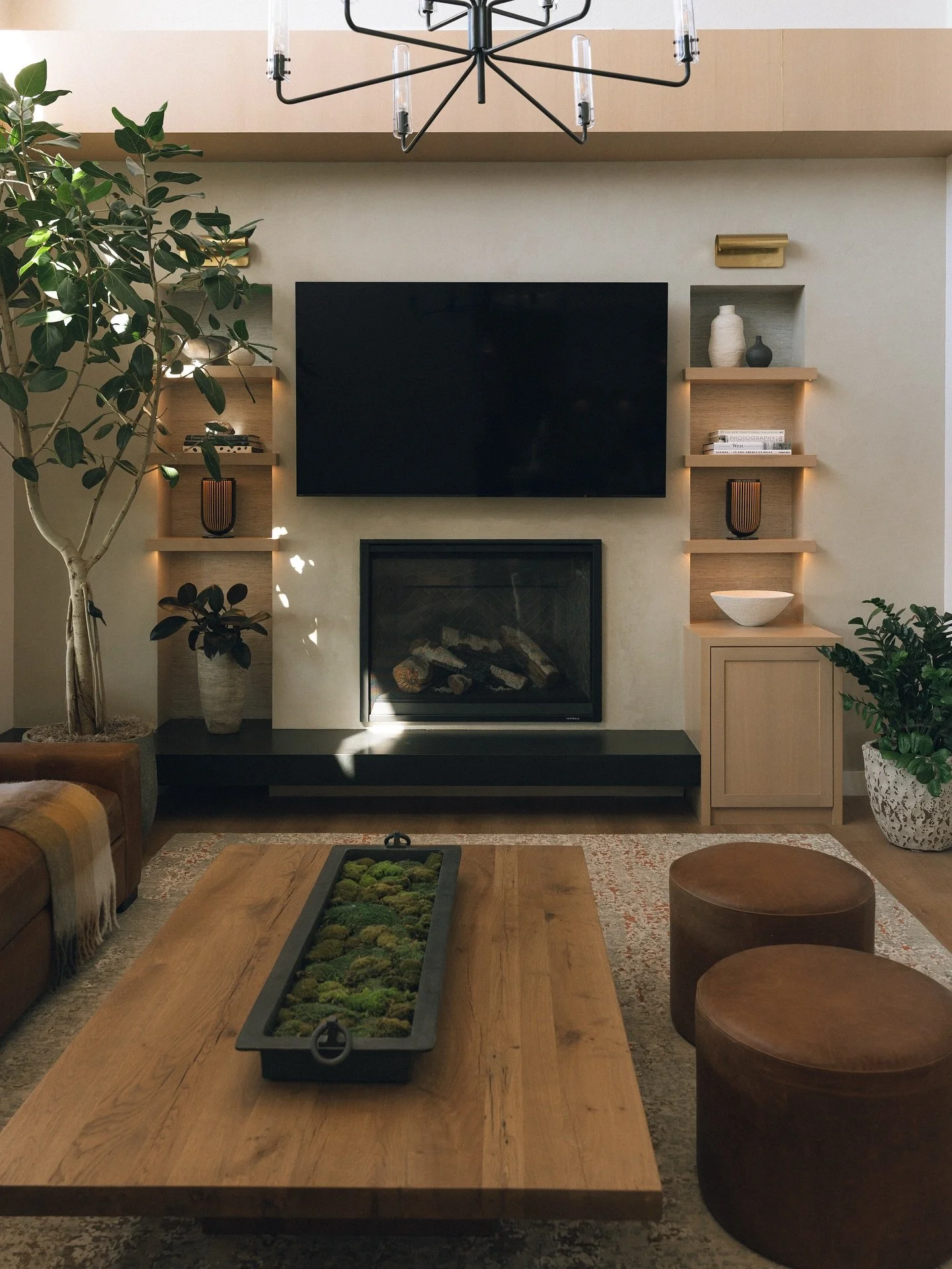 A fresh new family room for our Coto clients!
We modernized the space with rift-sawn white oak cabinetry, a sleek black leathered quartzite bench, and a textured wallpaper to bring depth and texture to the shelving. We added a gorgeous wood beam for 
