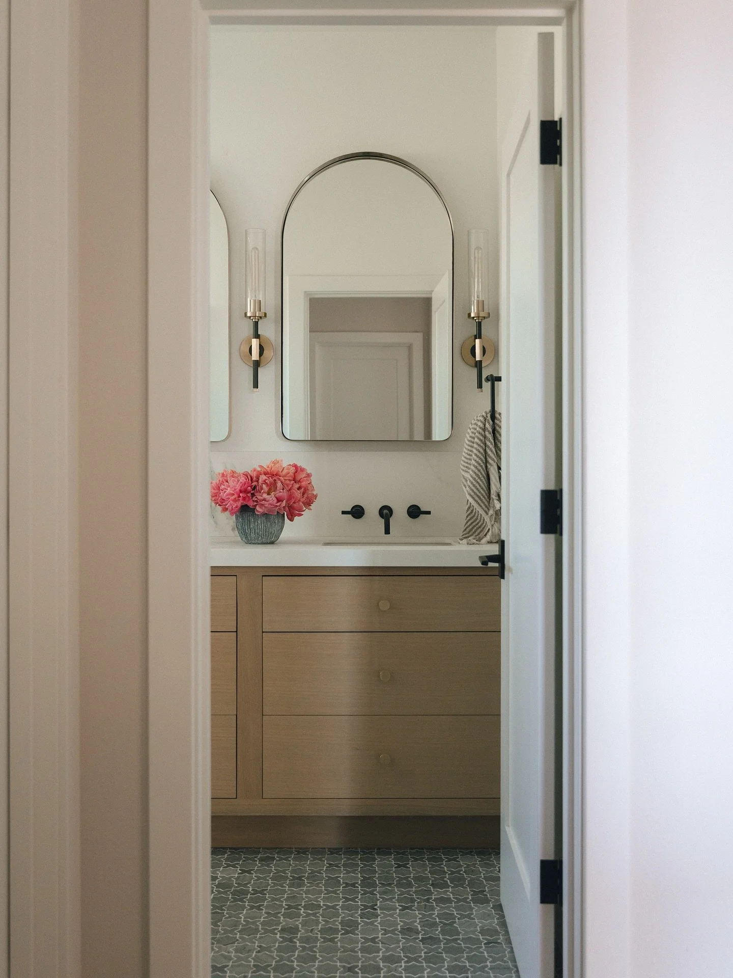 We loved transforming this guest bathroom in our Coto project into a timeless retreat that will serve our clients for years to come. The marble mosaic star-and-cross flooring adds just the right amount of charm and detail, while the porcelain slab co