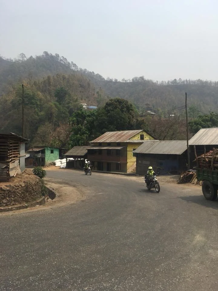 Nepal bikes riding through small village.jpg
