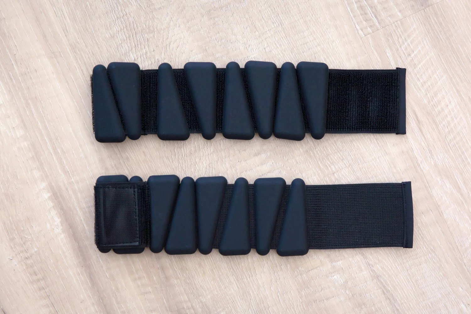 Pair of black adjustable wrist and ankle weights with silicone weights and fastening straps