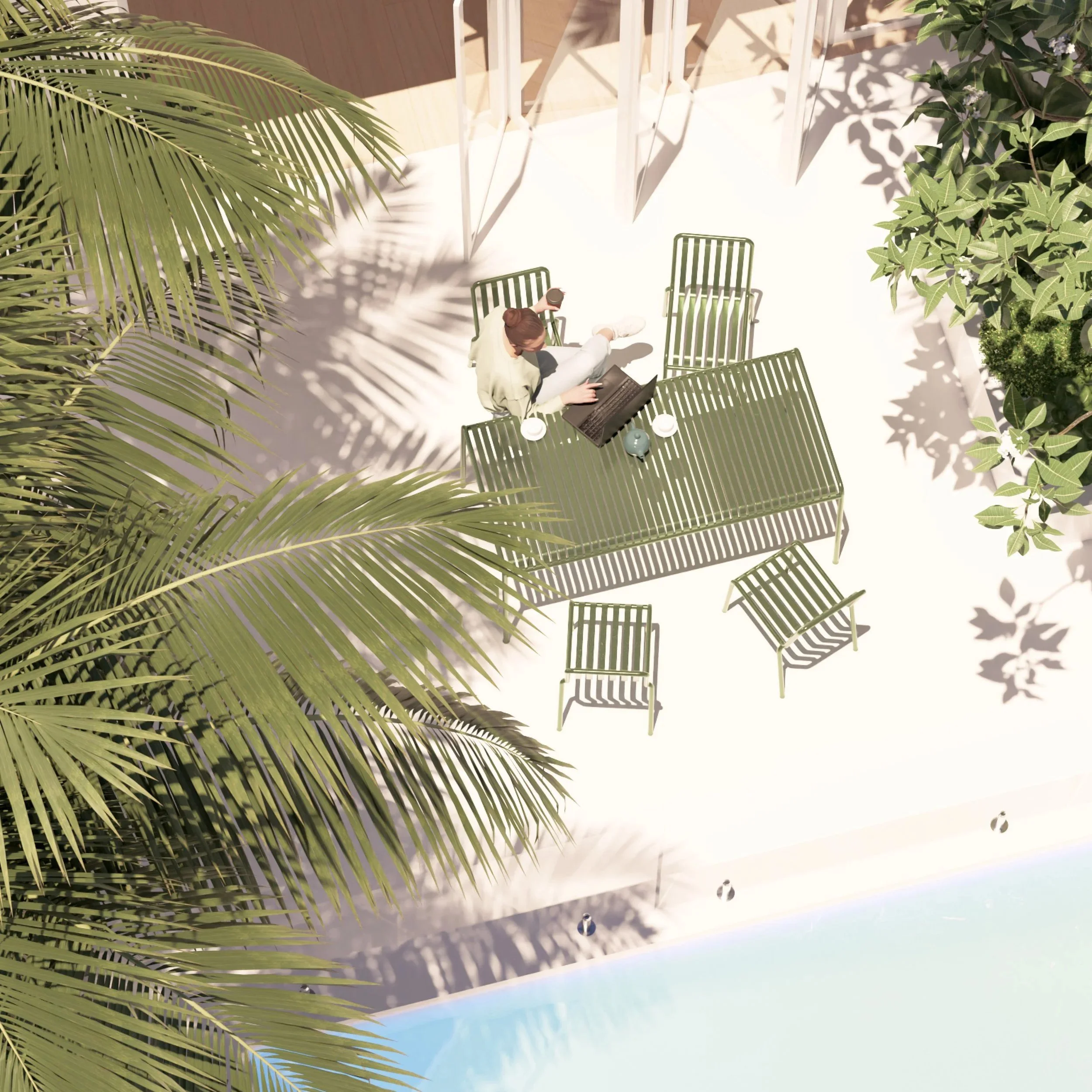 Oblique view of a woman working on a laptop at an outdoor table beside the pool in the Bondi courtyard garden, with bifold doors opening to the rear of the house.