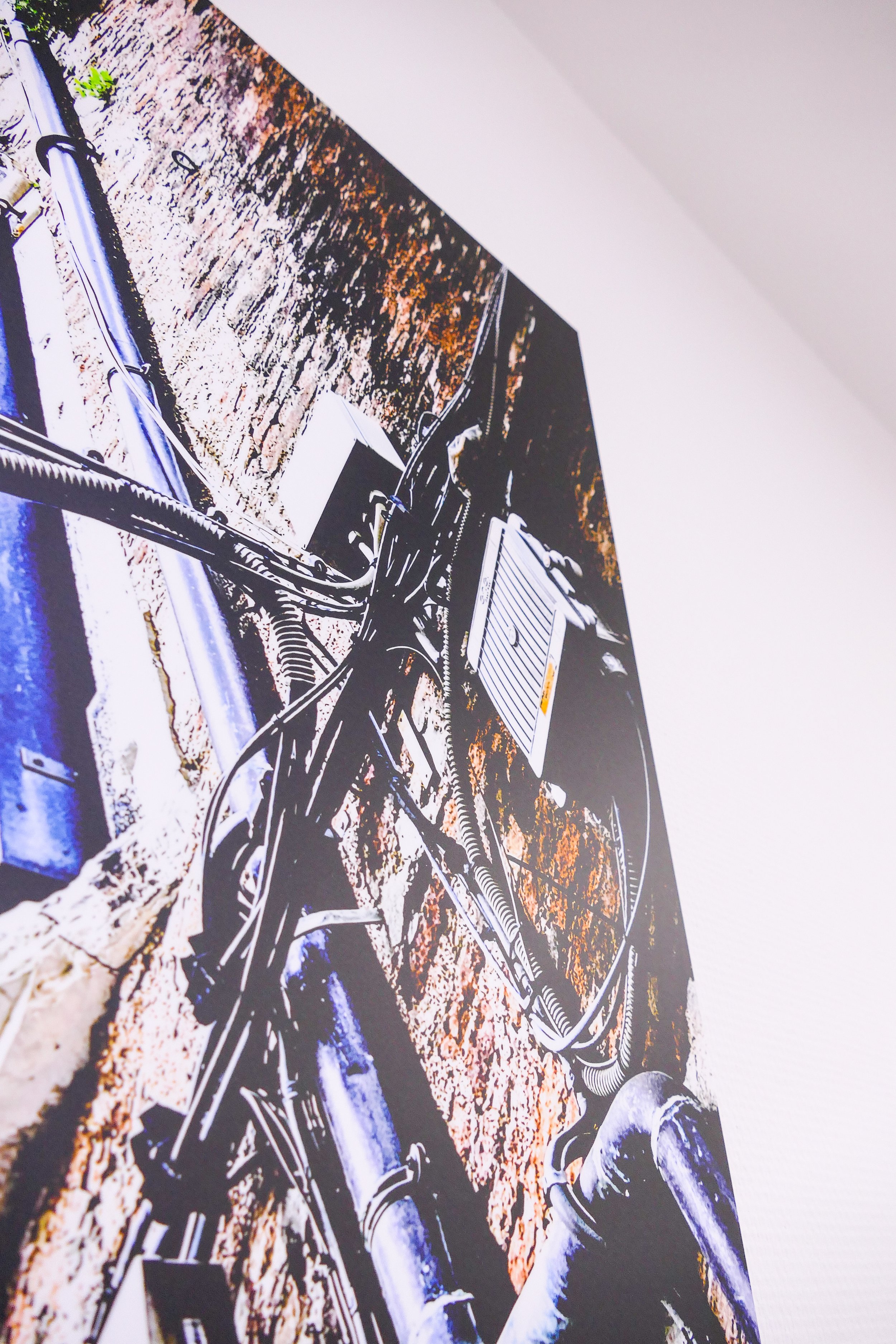 Draufsicht auf die Verkabelung und Rohre an einer Wand, vermutlich in einem Keller oder technischen Bereich.