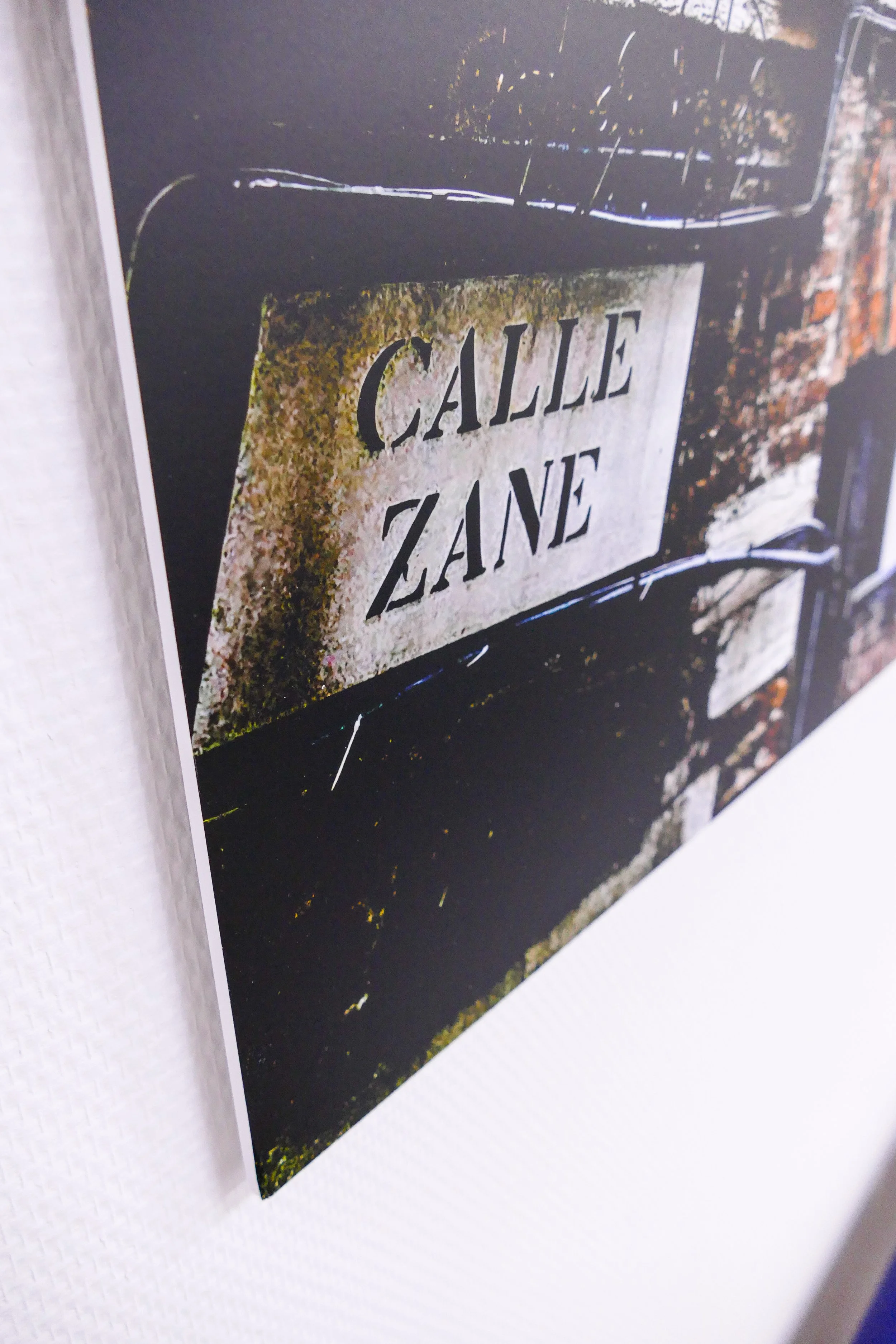 Straßenschild mit der Aufschrift 'Calle Zane' an einer Mauer