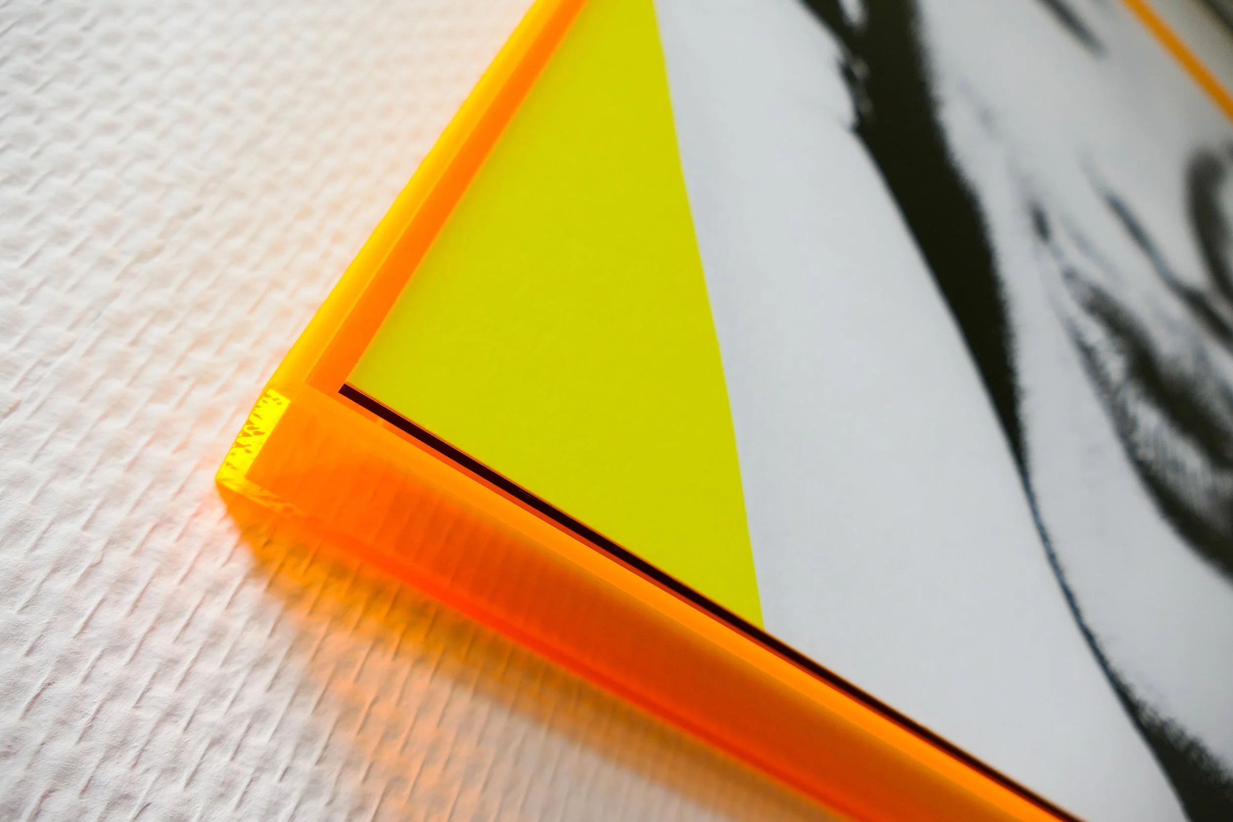 Nahaufnahme eines orangefarbenen reflektierenden Verkehrszeichens mit gelbem Dreieck und schwarzen Umrissen auf weißem Hintergrund.