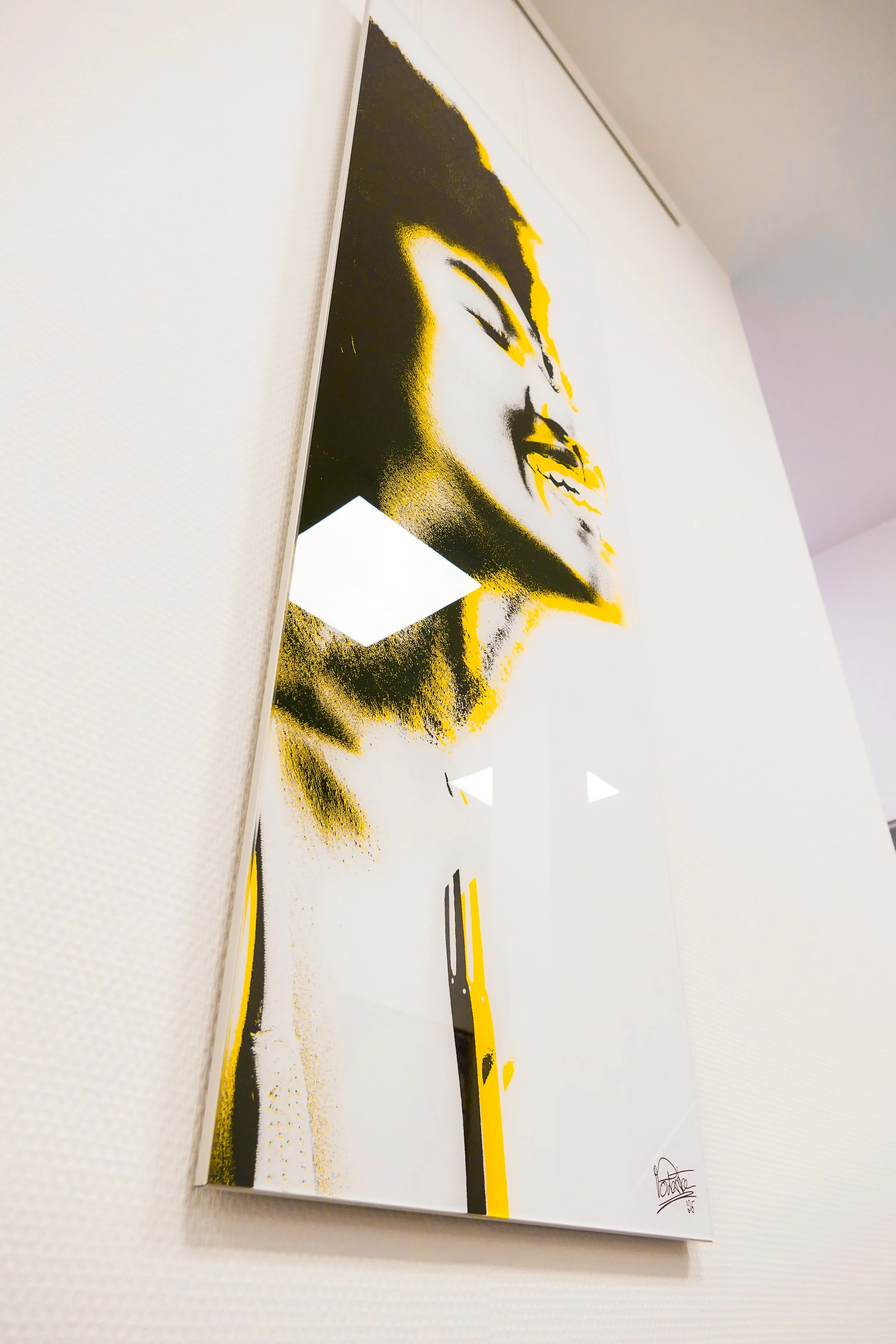 Abstraktes Kunstwerk eines lachenden Gesichts in Schwarz, Weiß und Gelb.