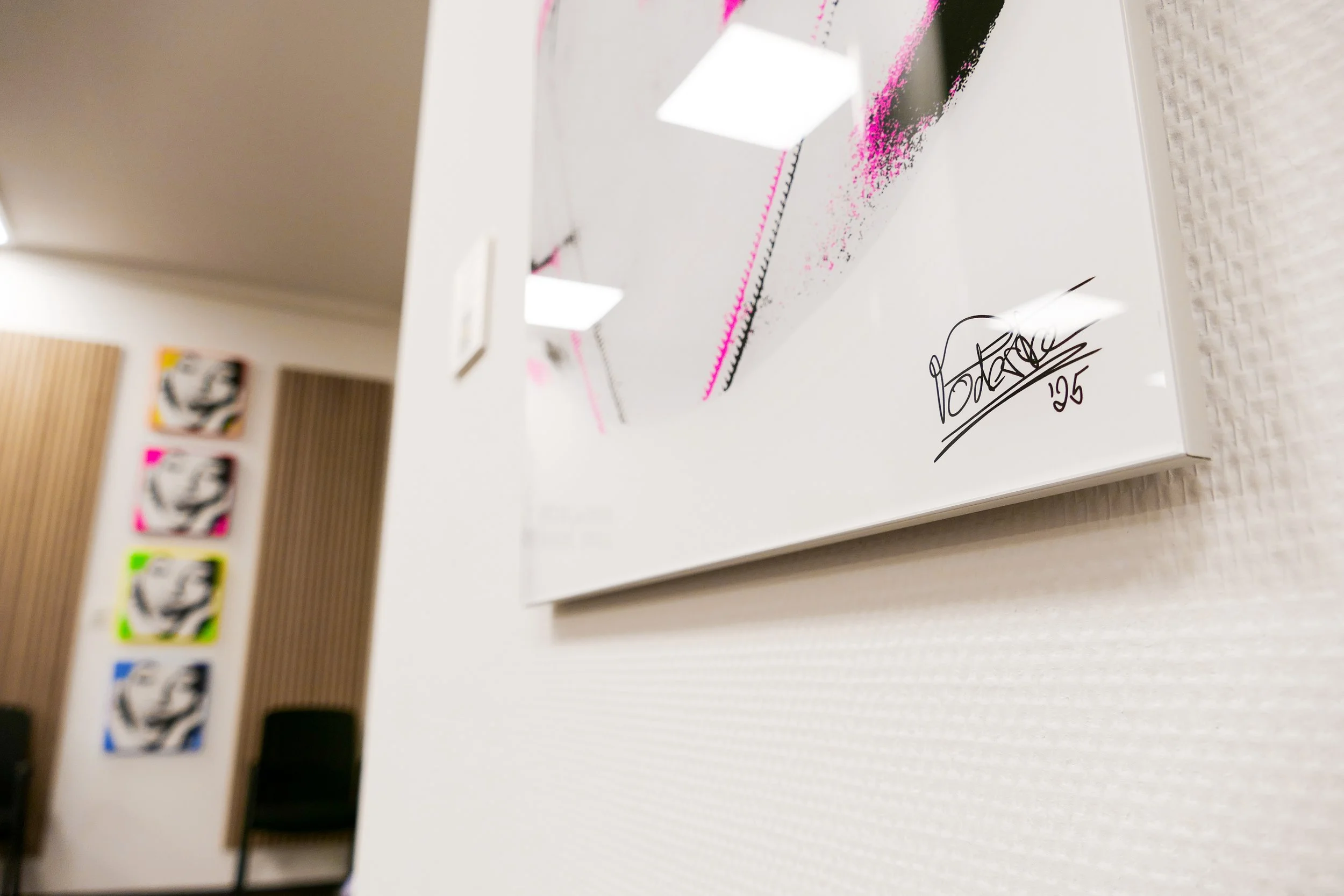 Kunstwerk auf weißem Rahmen an einer weißen Wand mit Signatur und Jahr '95'