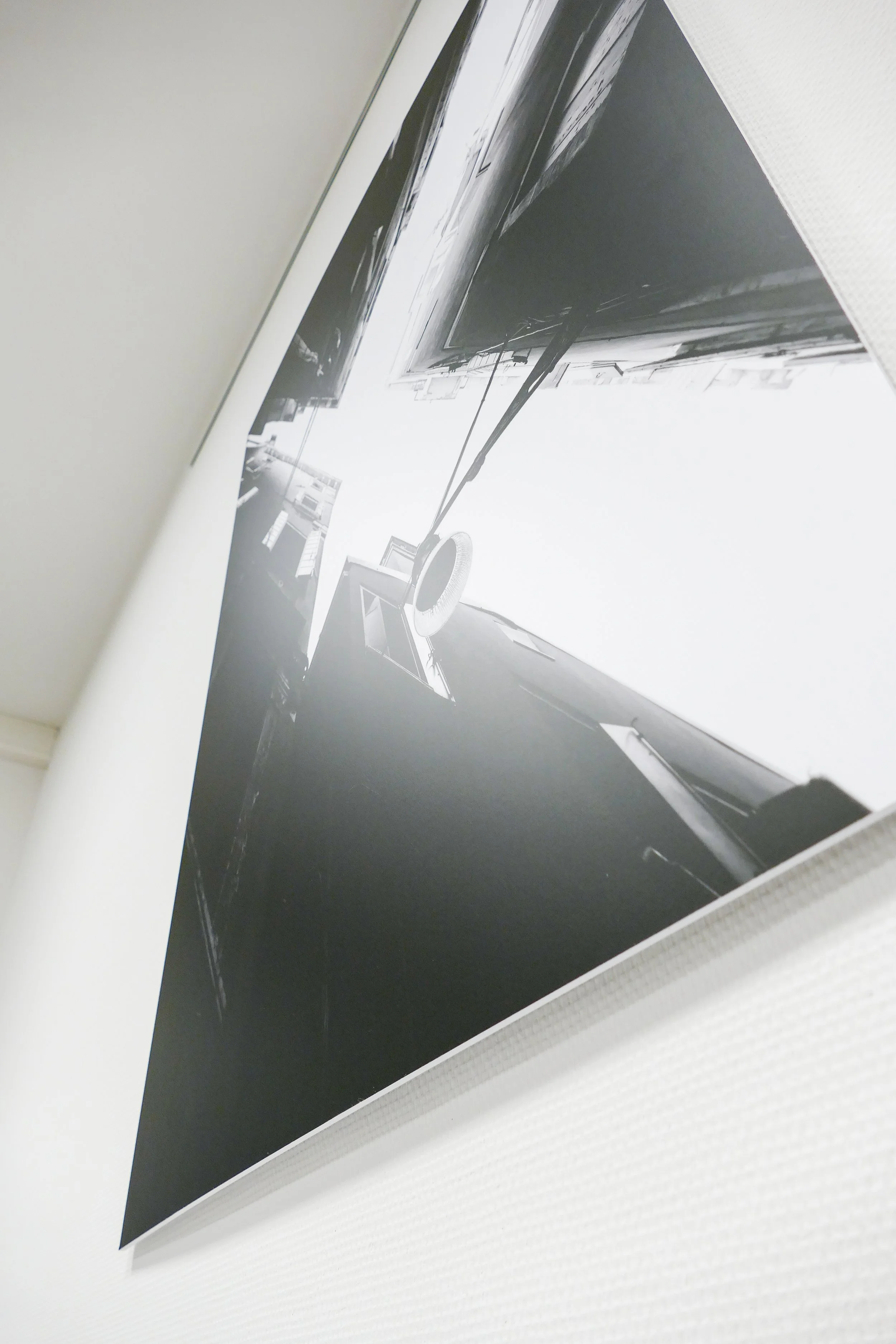 Schwarz-weiß-Fotografie eines modernen Gebäudes, aufgenommen von unten, mit Blick nach oben