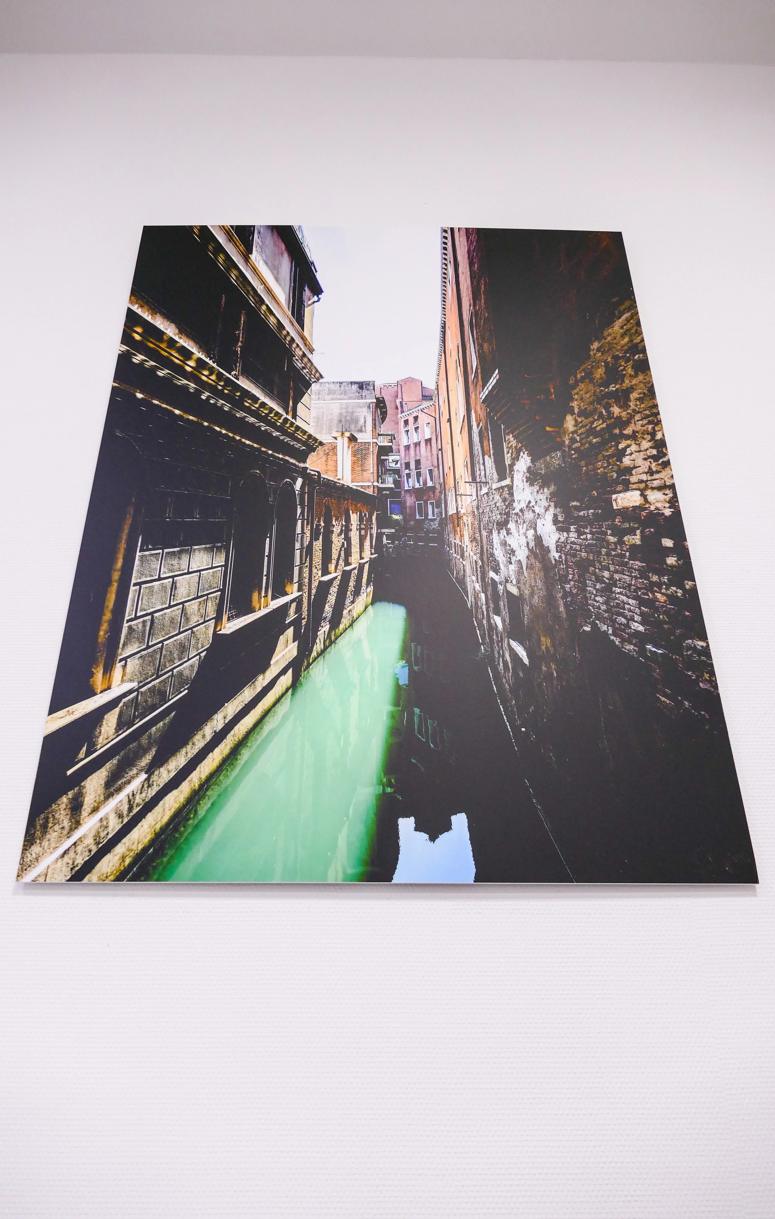 Fotografie eines Kanals in einer alten Stadt mit Gebäuden auf beiden Seiten, bei Tageslicht aufgenommen.