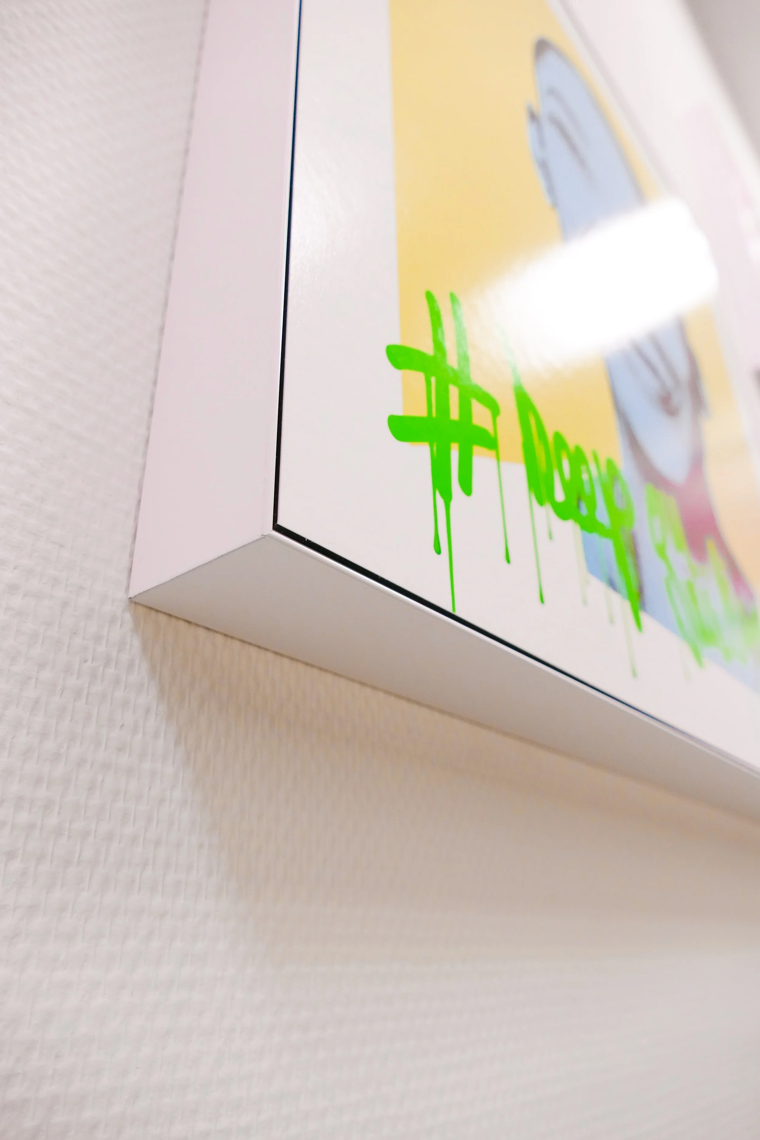 Verpackung mit grüner Graffiti-Schriftzug auf weißem Hintergrund, leicht schräg betrachtet.