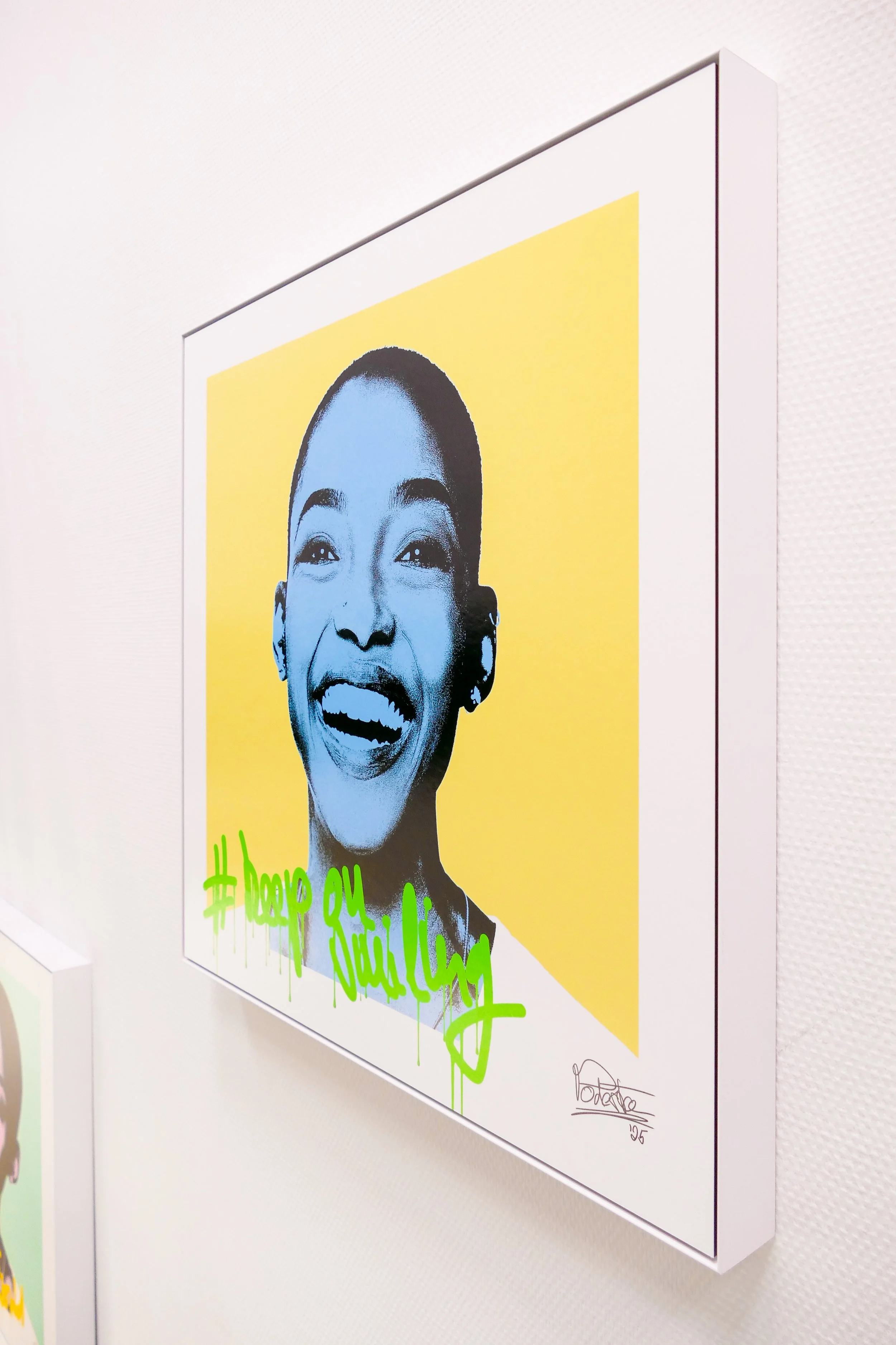 Gemälde eines lachenden schwarzen Mädchens mit gelbem Hintergrund und grüner Graffiti-Schriftzug mit dem Hashtag #keep on smiling.