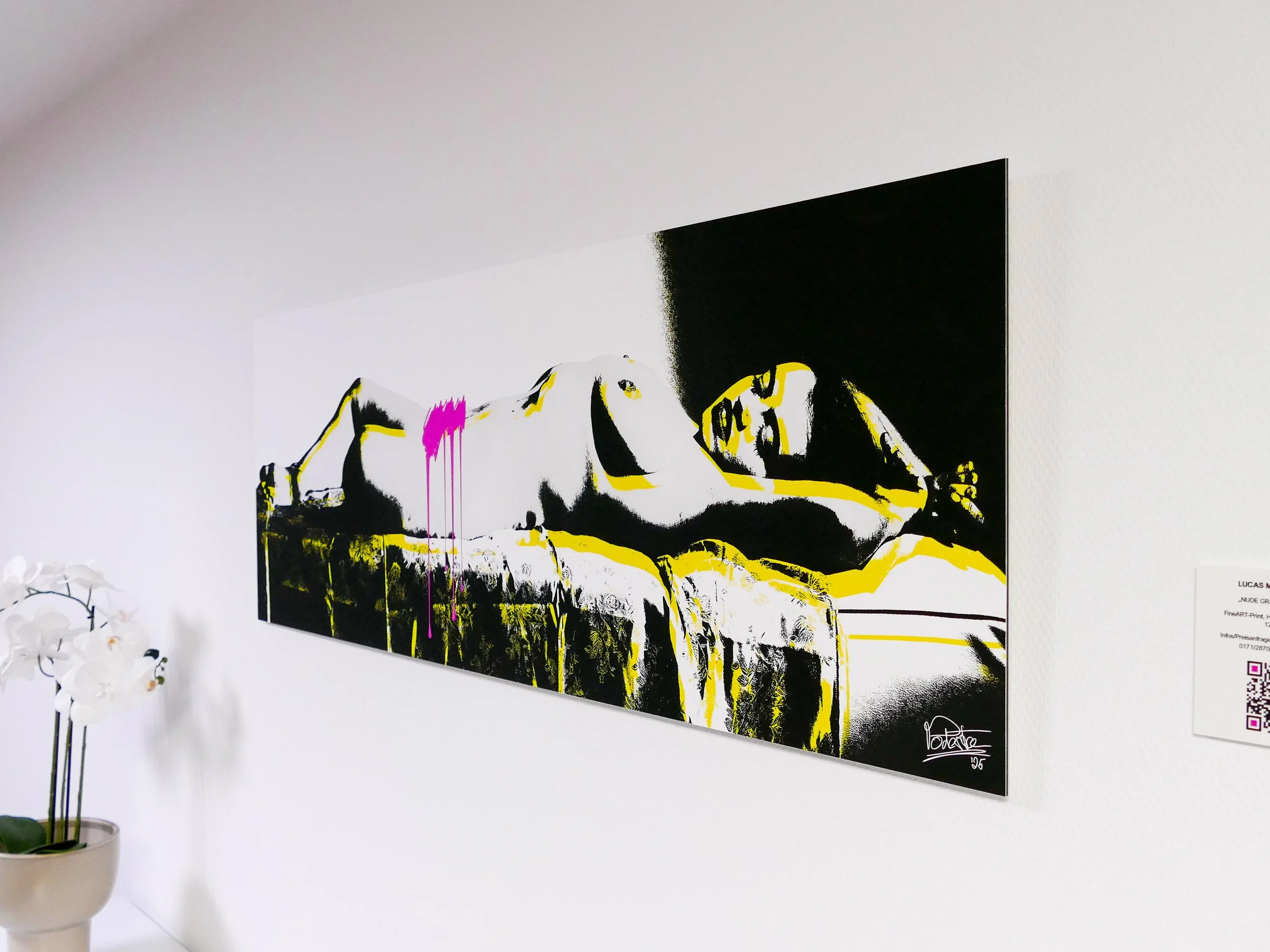 Moderne Wandkunst eines nackten Frauenkörpers in Schwarz, Weiß, Gelb und Magenta, mit einem schwarzen Hintergrund auf einer weißen Wand, neben einer Orchideenpflanze.