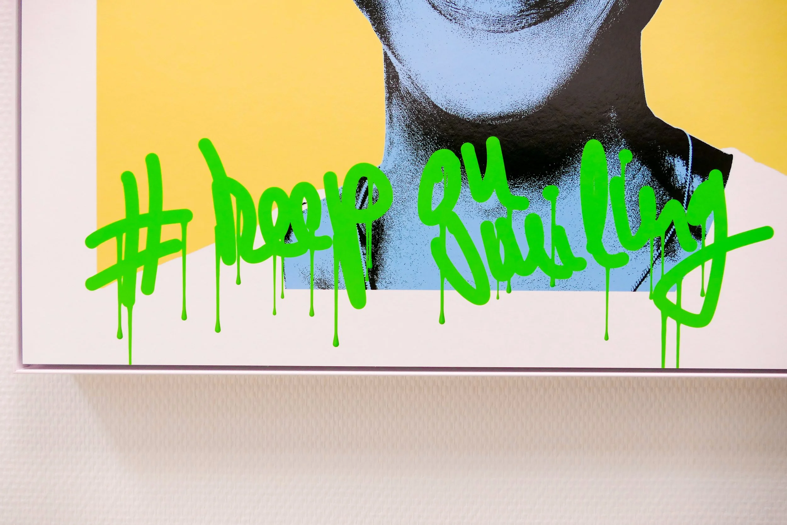 Kunstwerk mit einem Schwarz-Weiß-Porträt eines Menschen, der eine weiße Jacke trägt, und grüner Graffiti-Schrift, die #keep on smiling erscheint, mit Pinselstrichen und Sprühdetails.
