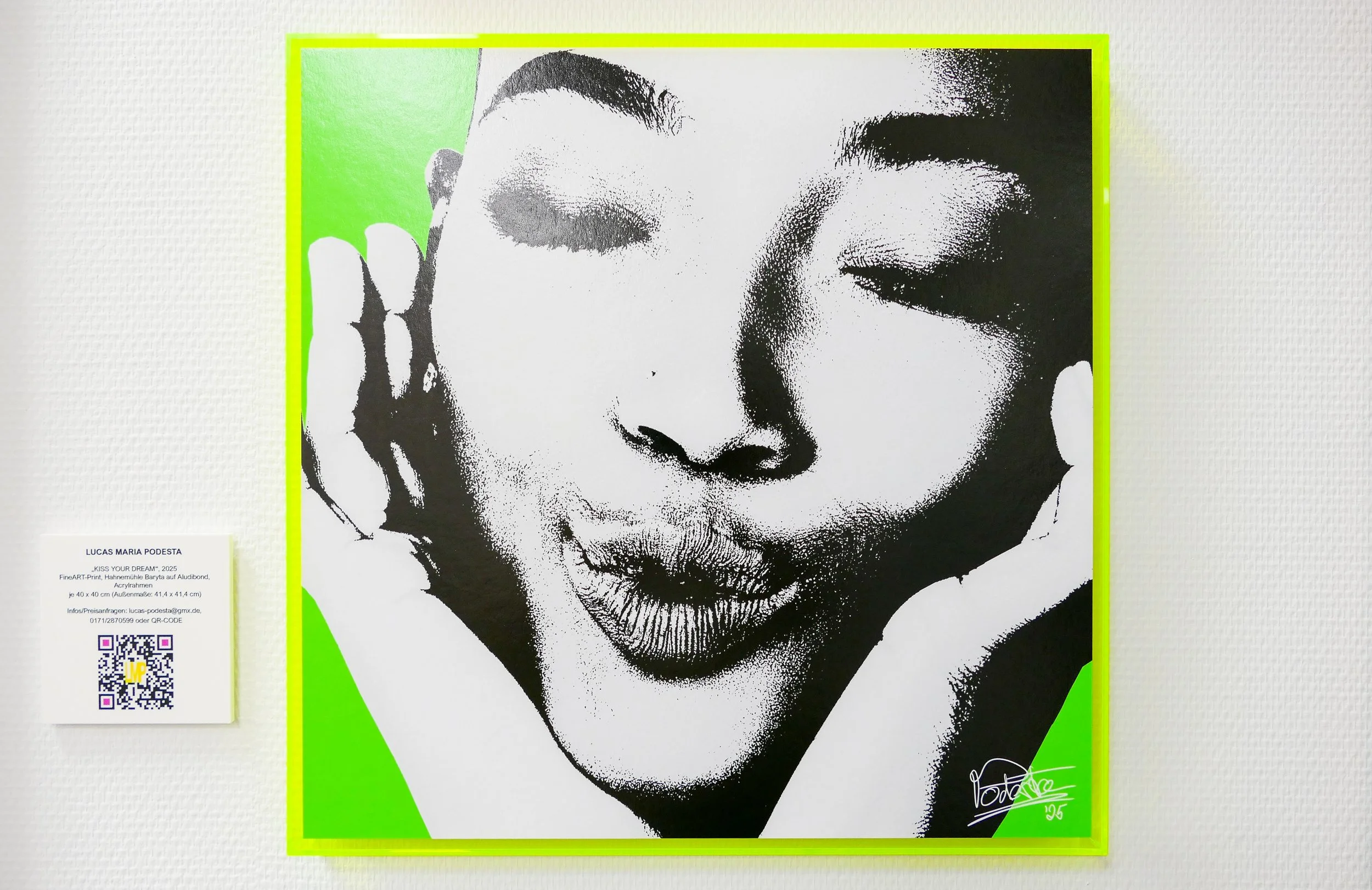 Schwarz-weiß Porträt eines lachenden Mädchens mit geschlossenen Augen, die Hände an den Seiten des Gesichts, auf grünem Hintergrund, an der unteren rechten Ecke signiert.