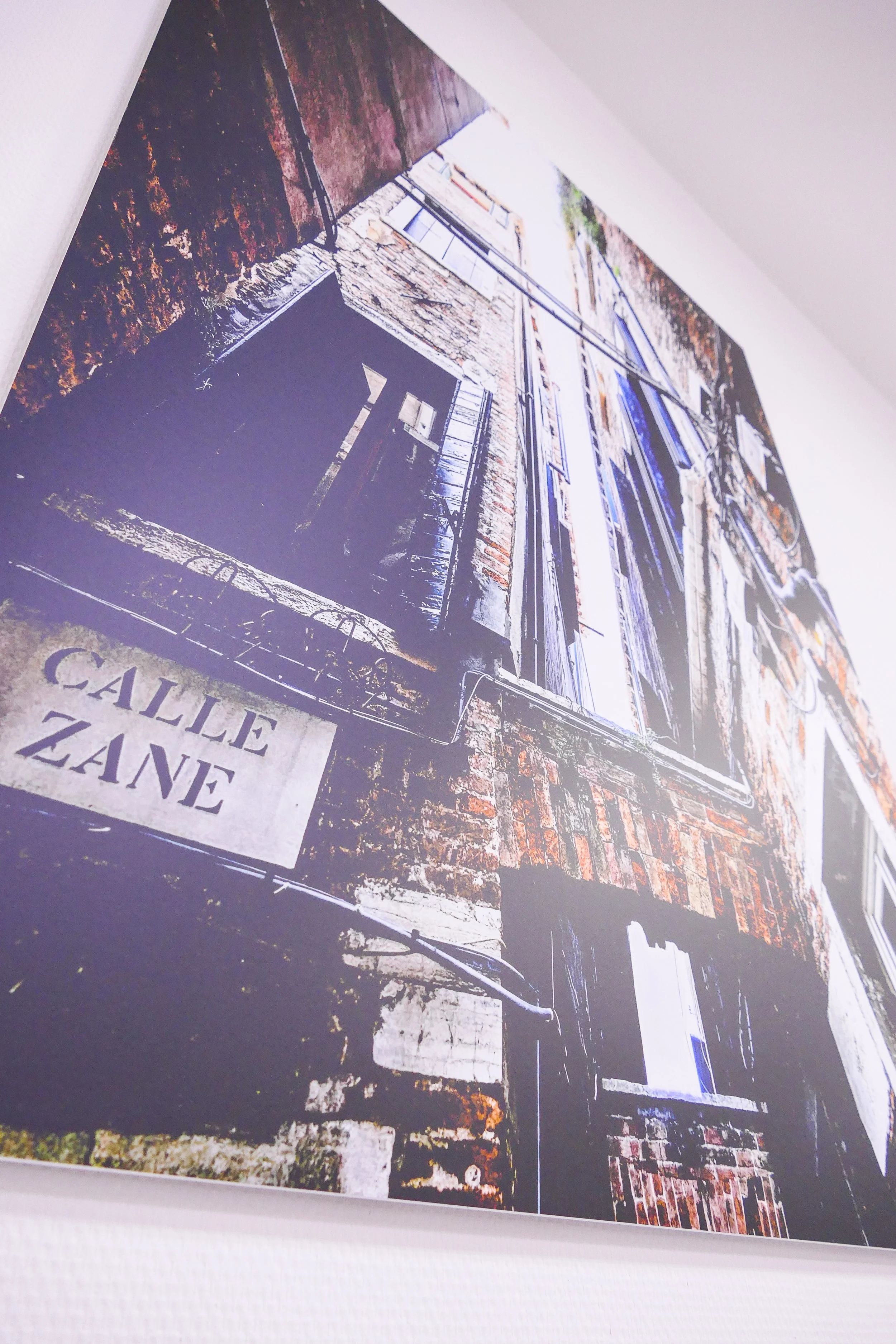 Aufnahme eines Wandfotos, das ein altes Gebäude mit abblätternder Farbe zeigt, mit einem Schild, das 'CALE ZANE' liest.