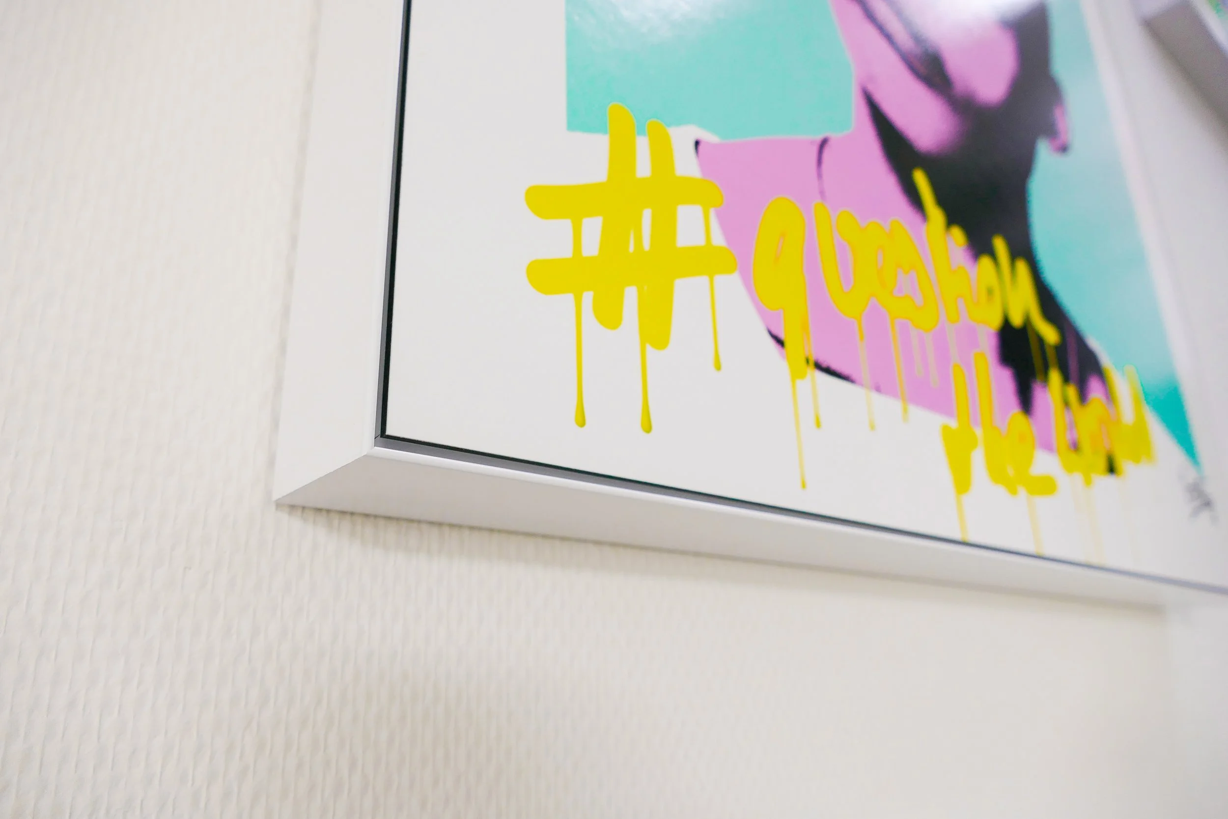 Kunstwerk mit bunten Farben und gelber Graffiti-ähnlicher Schrift auf weißem Hintergrund