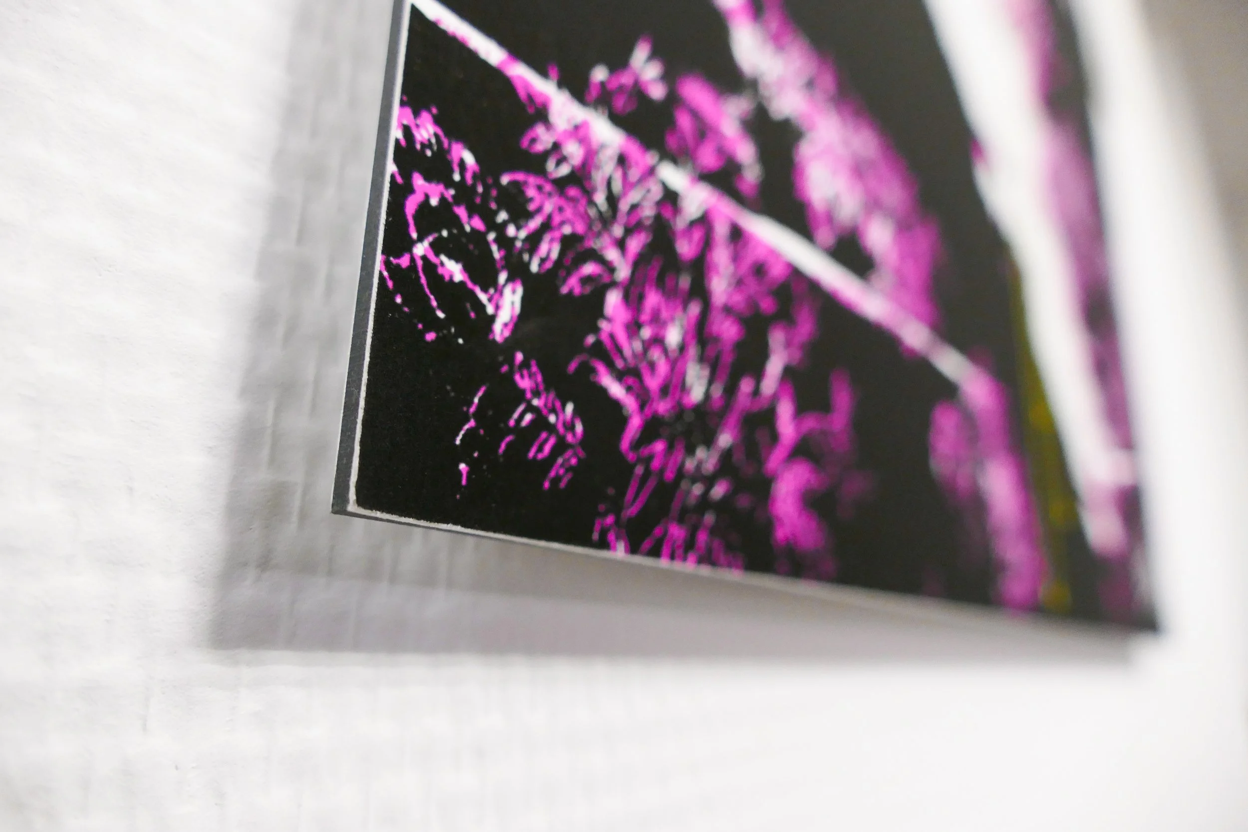 Kunstwerk mit rosa und gelben Linien auf schwarzem Hintergrund.