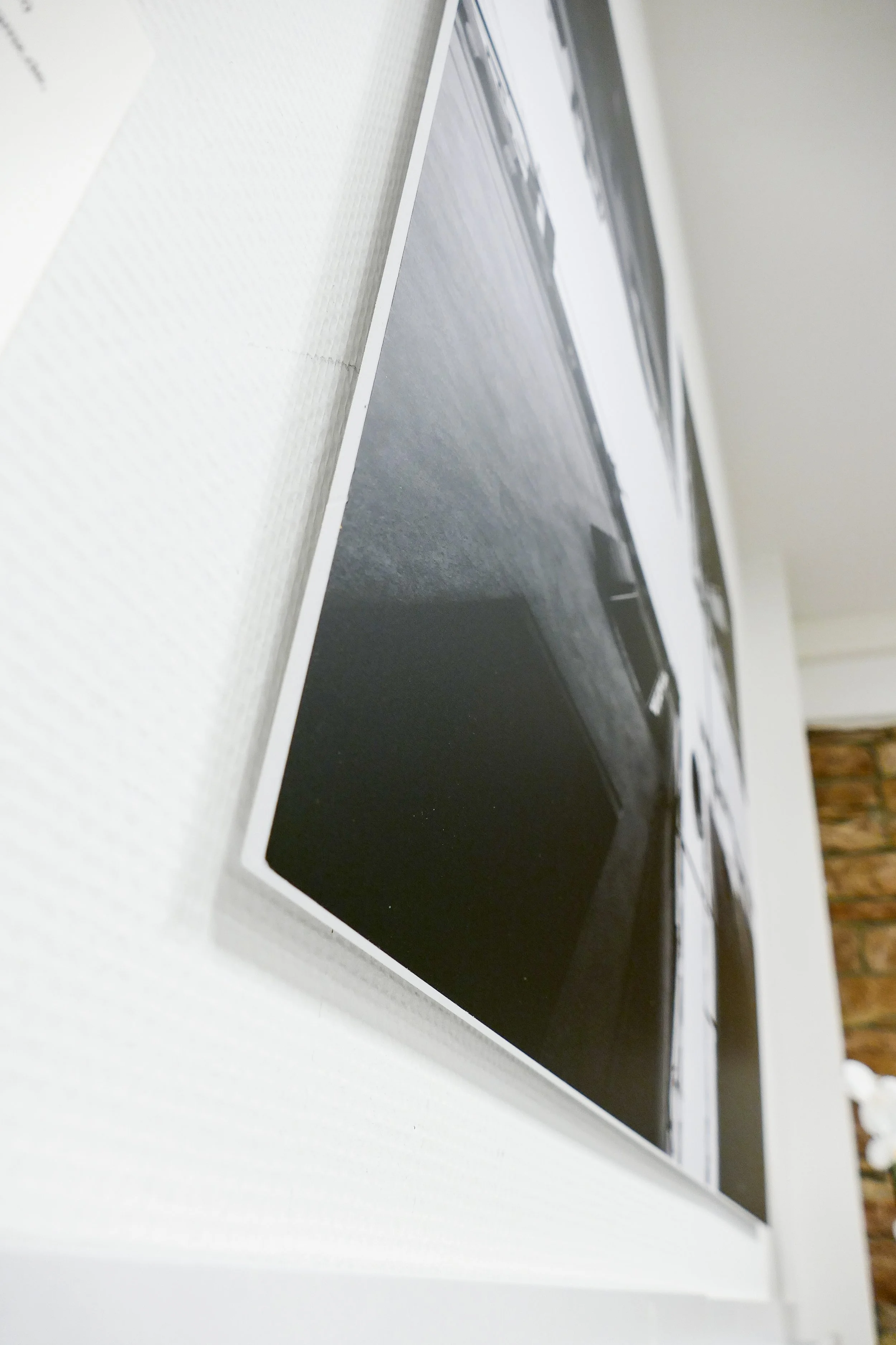 Nahaufnahme eines schwarzen elektronischen Geräts, möglicherweise ein Computer oder eine Konsole, auf einer weißen Oberfläche.