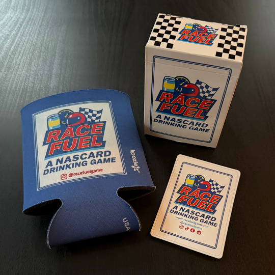 Race Fuel NASCAR drinking game set including a cardboard box, a blue koozie, and a deck of cards on a black surface.