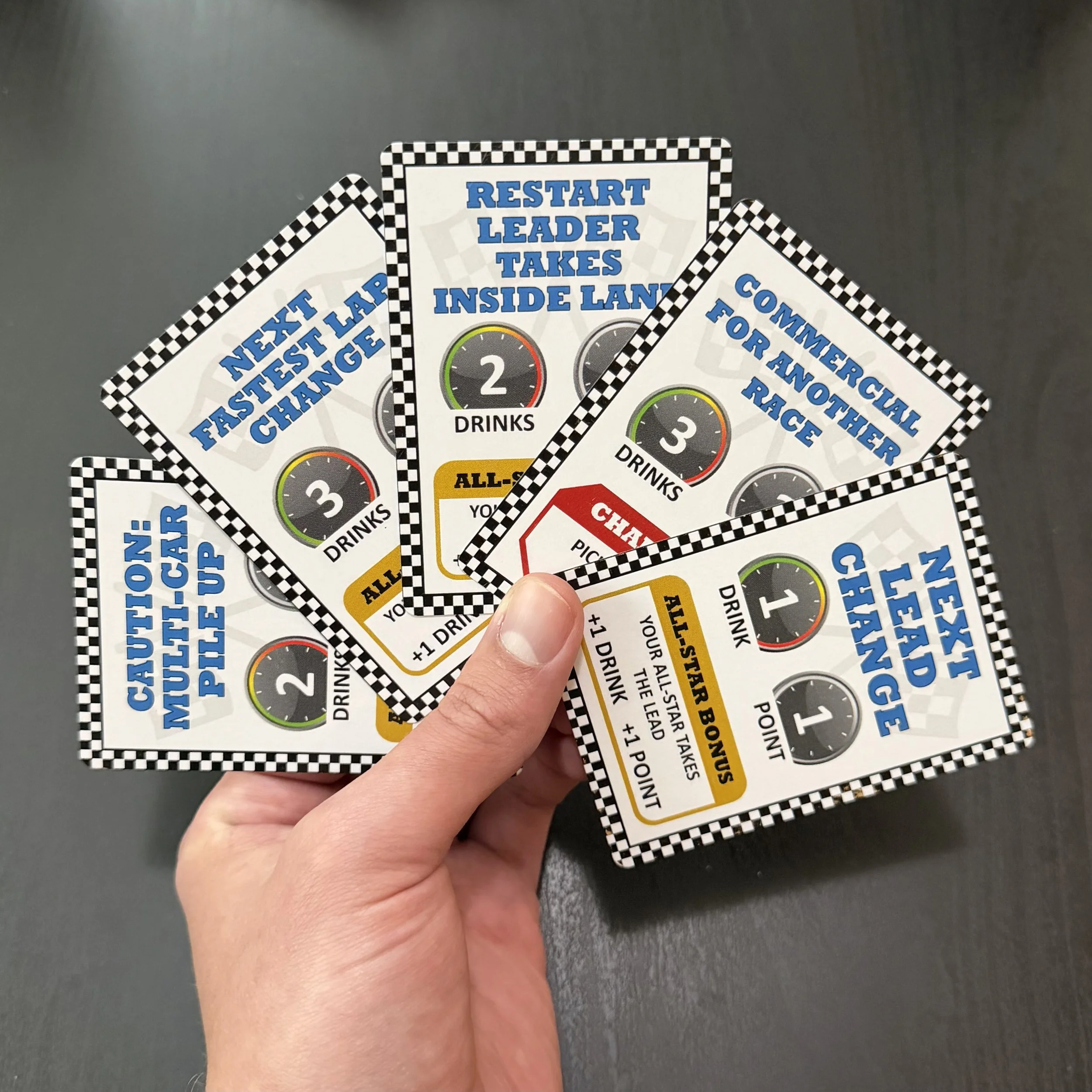Player holding Race Fuel racing card game cards with live race event cards and All-Star bonus cards.