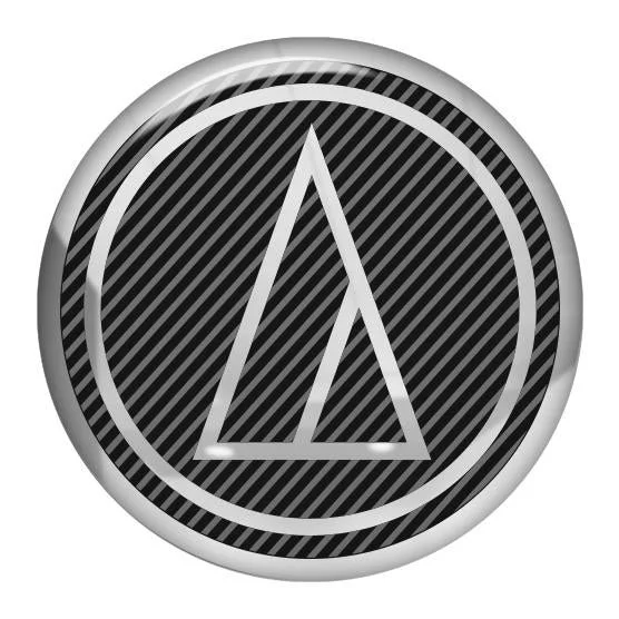 A circular emblem with a black background and diagonal stripes, featuring a white triangle with an elongated apex inside a white circle.