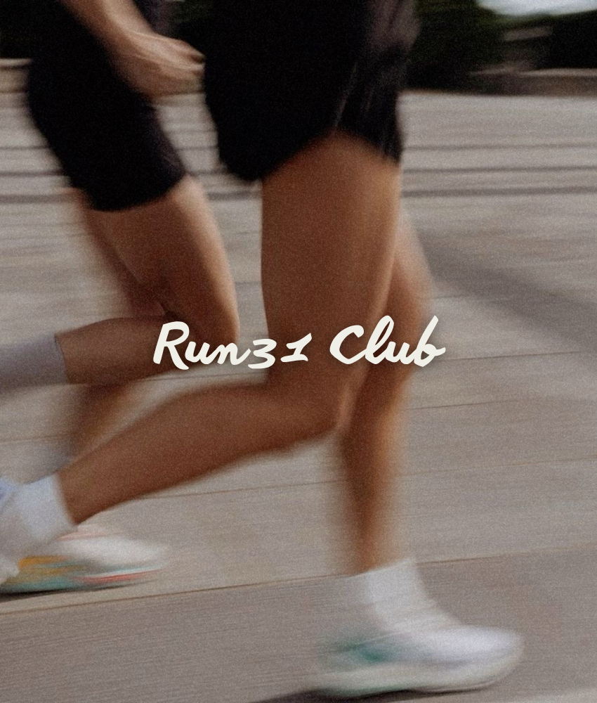 Run31 Club logo with a photo behind it with a person running outdoors on a wooden pathway, wearing white athletic shoes and black shorts