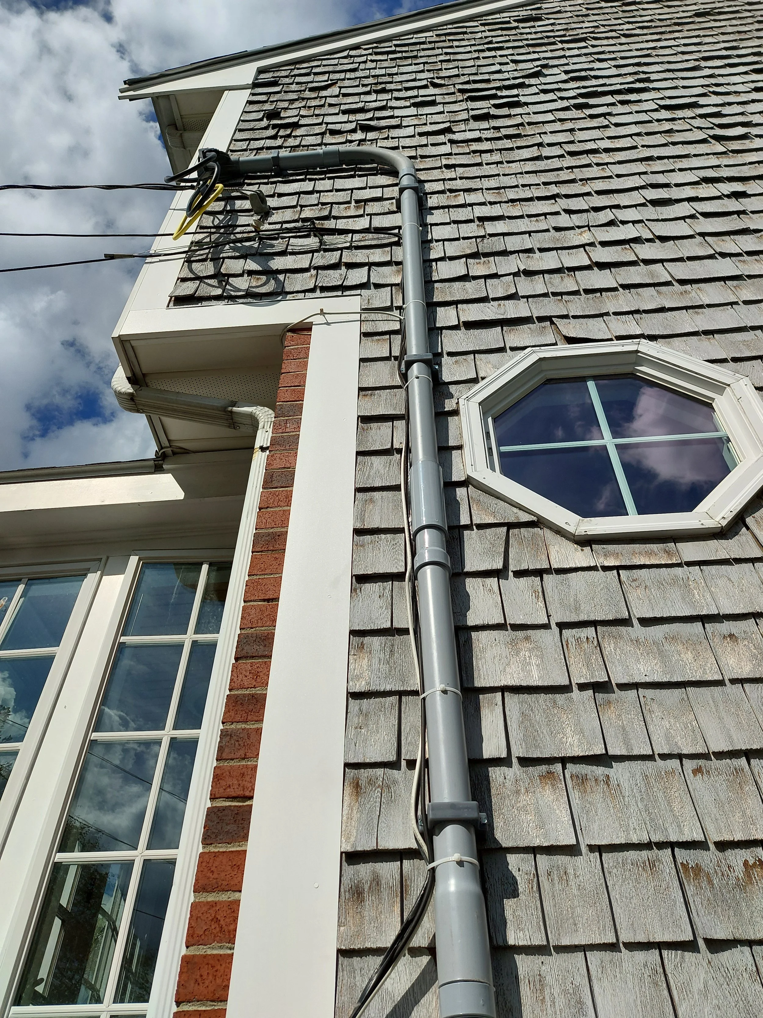 Exterior service mast and conduit for a Quincy, MA electrical service upgrade completed September 10, 2026.
