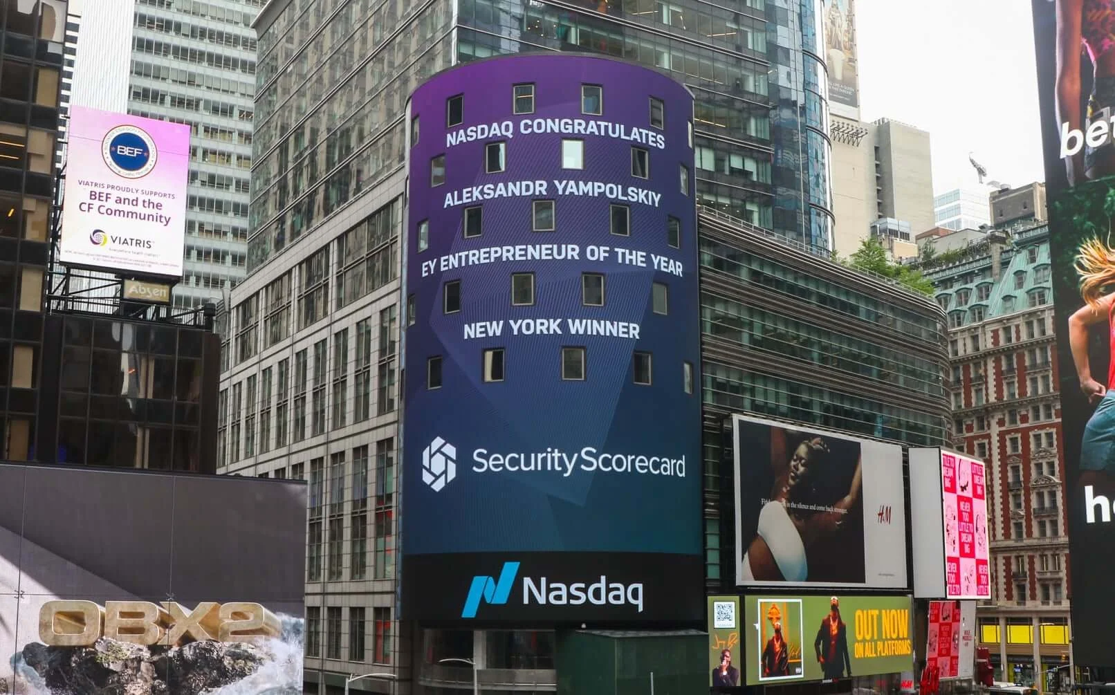 Digital billboard in Times Square celebrating Aleksandr Yampolskiy as NASDAQ Entrepreneur of the Year, New York winner, with Security Scorecard and NASDAQ logos.