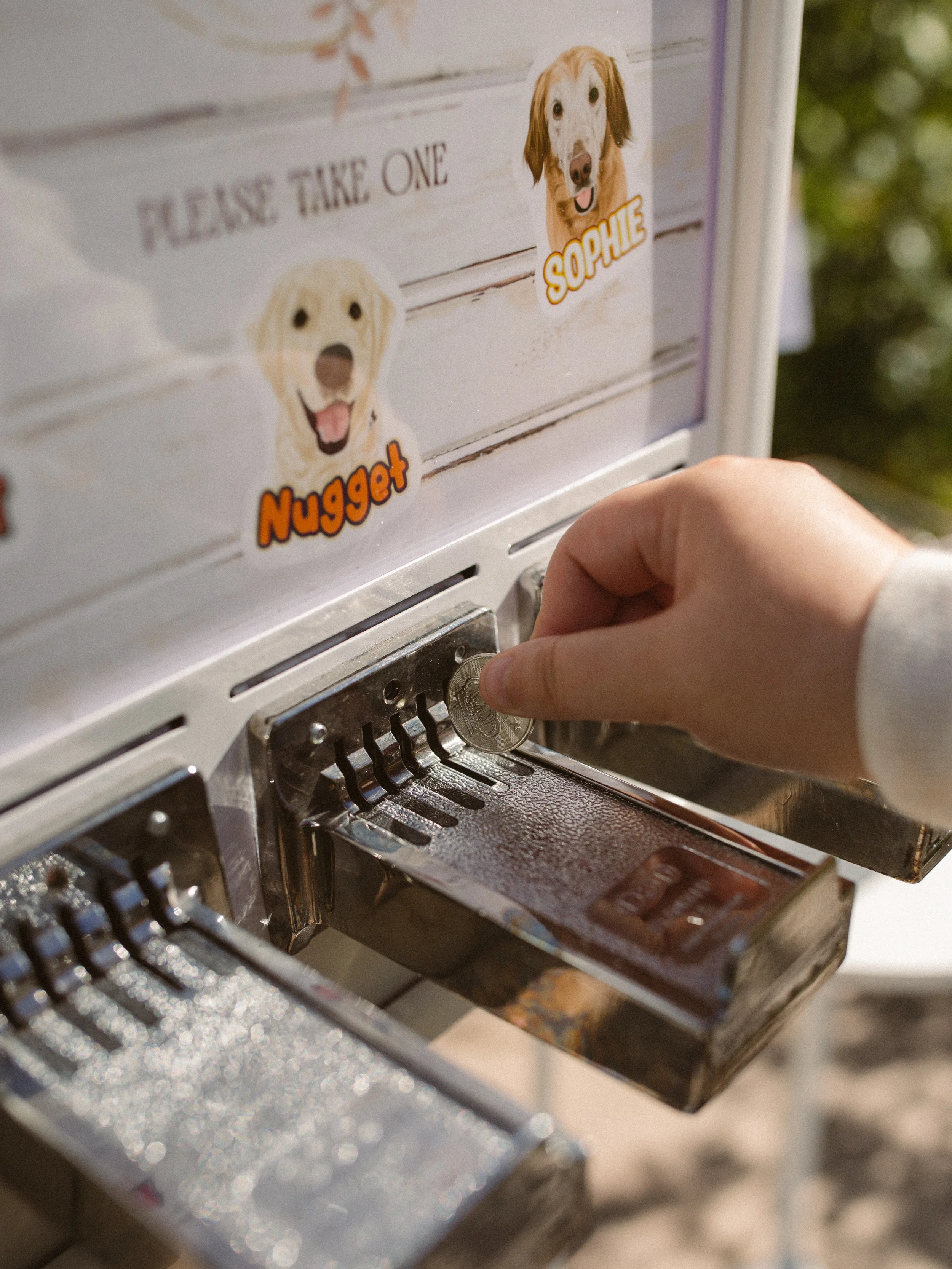 hand inserting token in sticker vending machine