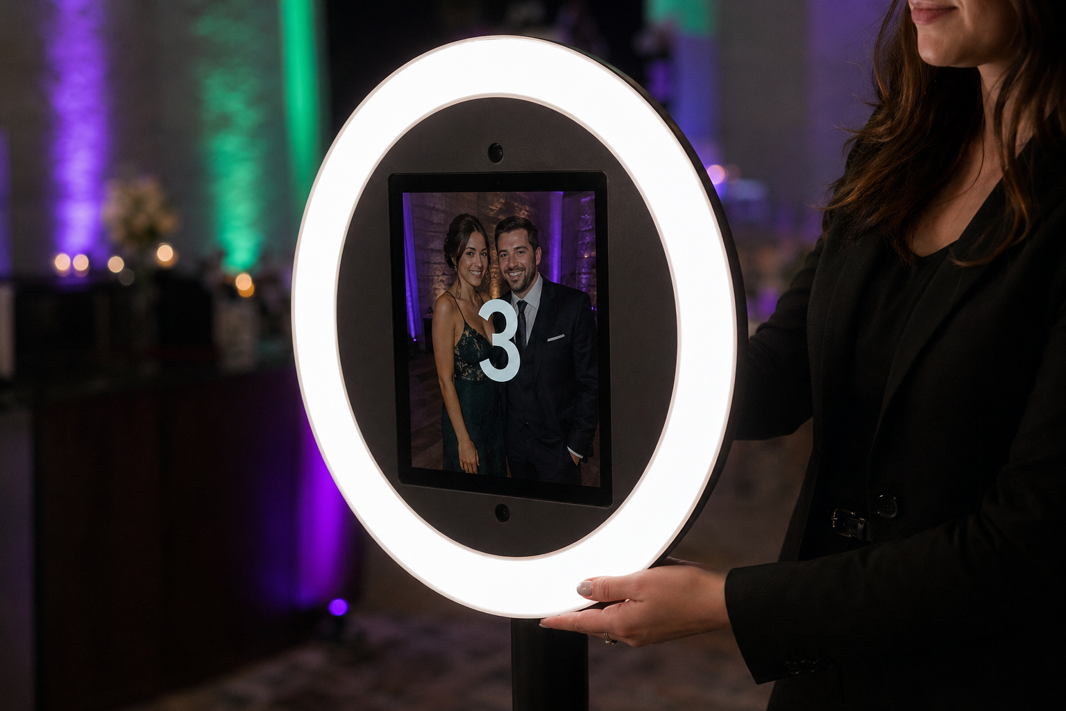 Roaming photo booth attendant holding ring light device mid-countdown at an upscale Southern California wedding reception
