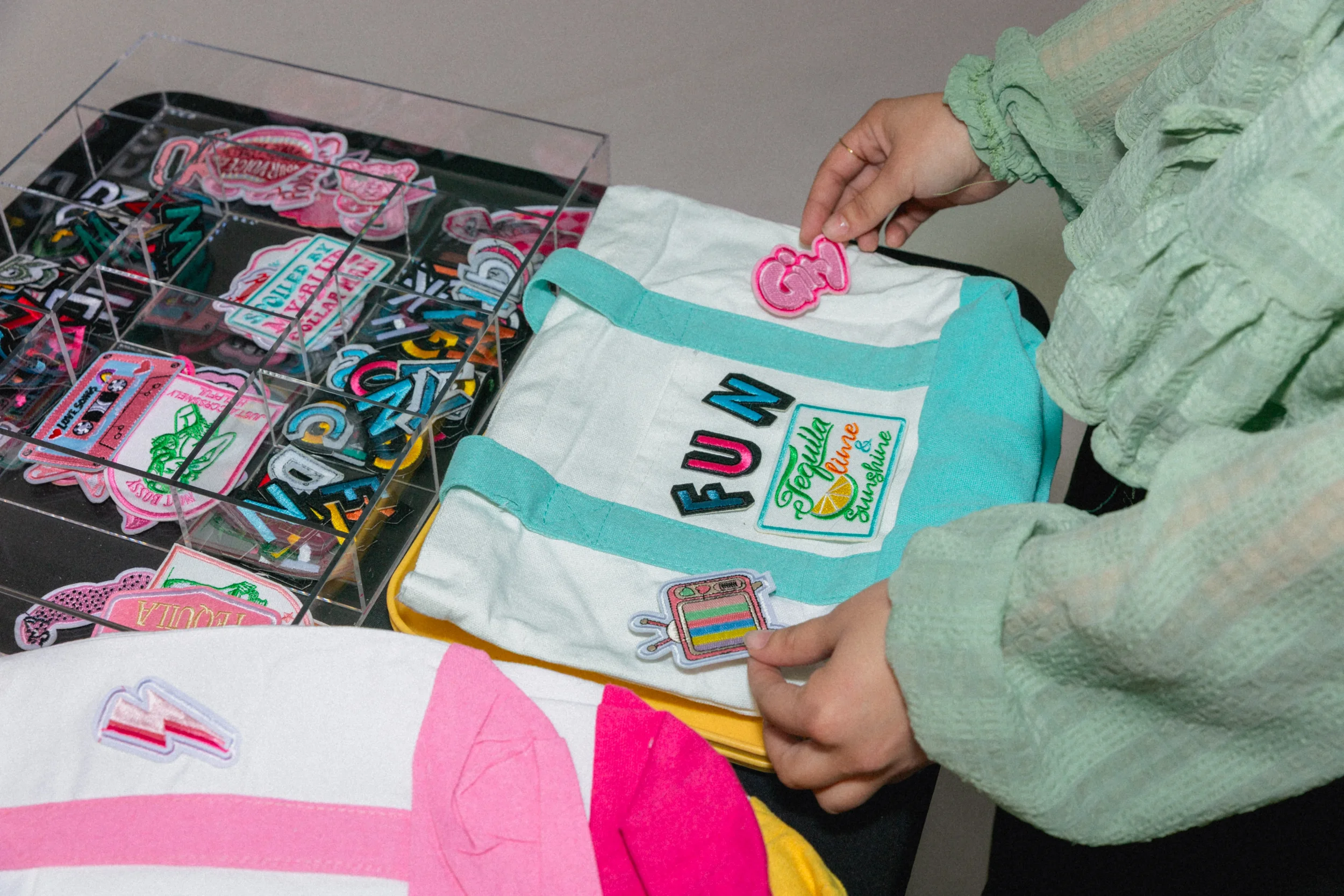Guest positioning patches on a tote bag before heat press application