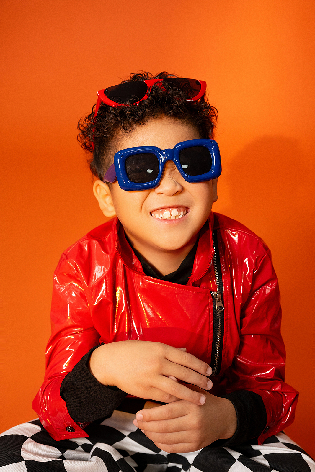 Boy sitting on vintage armchair for high-end studio portrait in NYC