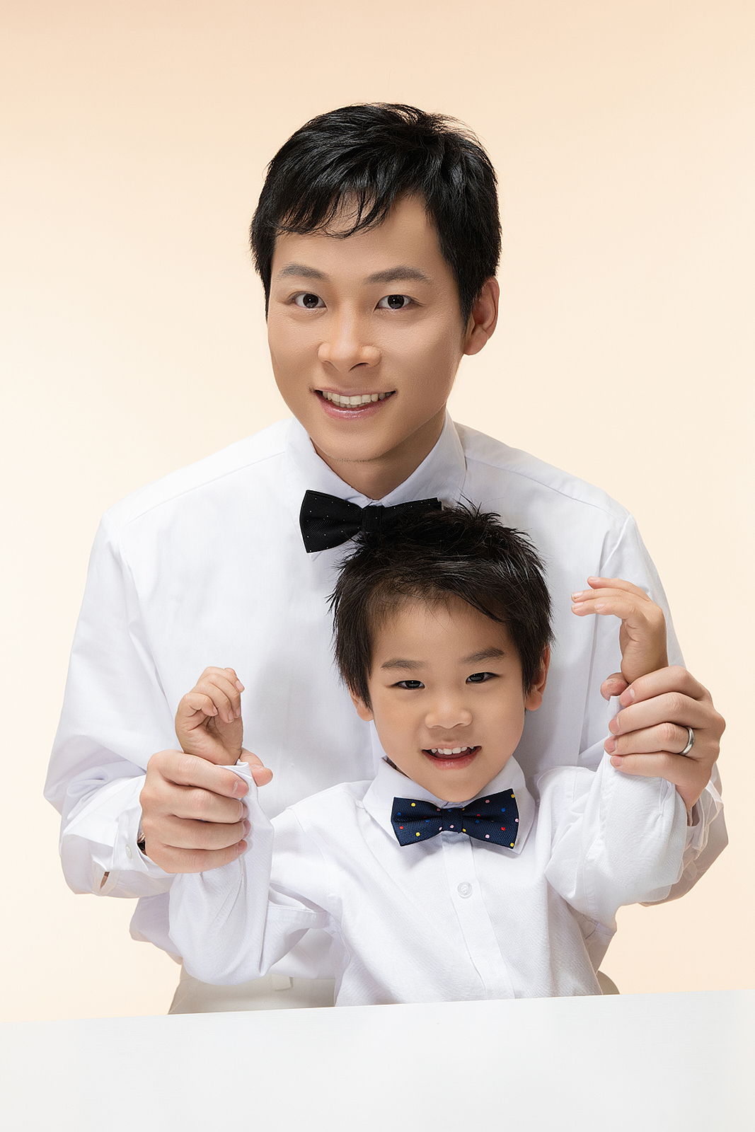 High-end studio family portrait with soft pastel backdrop in Flushing