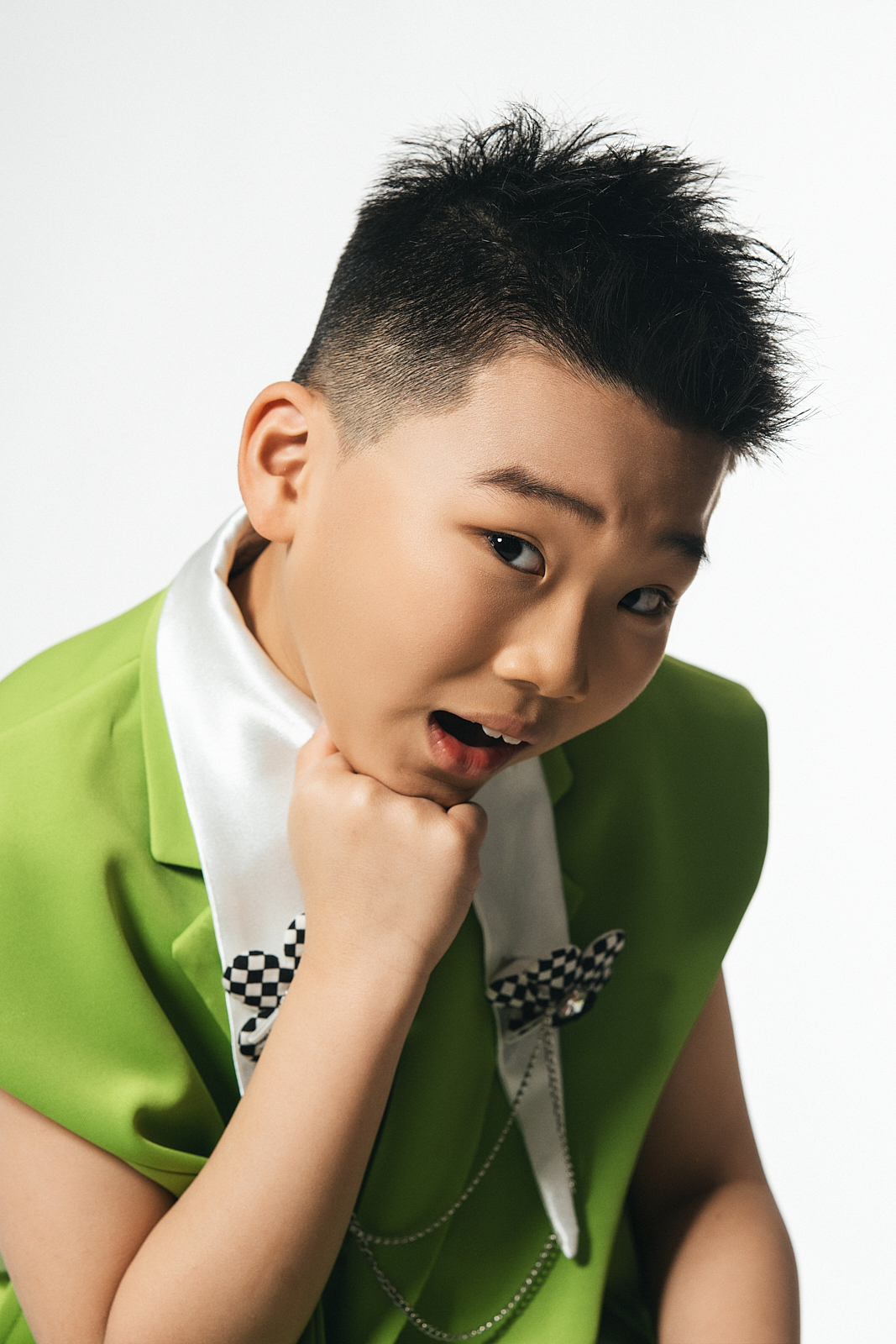 Boy wearing vintage cap and suspenders in high-end children’s fashion shoot, NYC