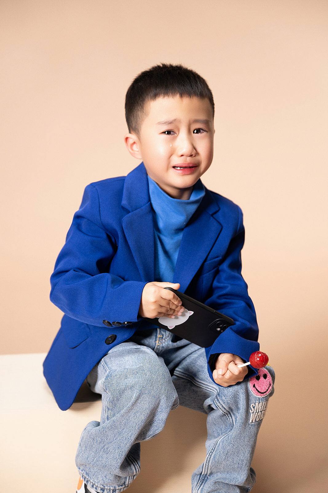 Boy leaning on vintage suitcase for fashion-inspired children’s photo in NYC