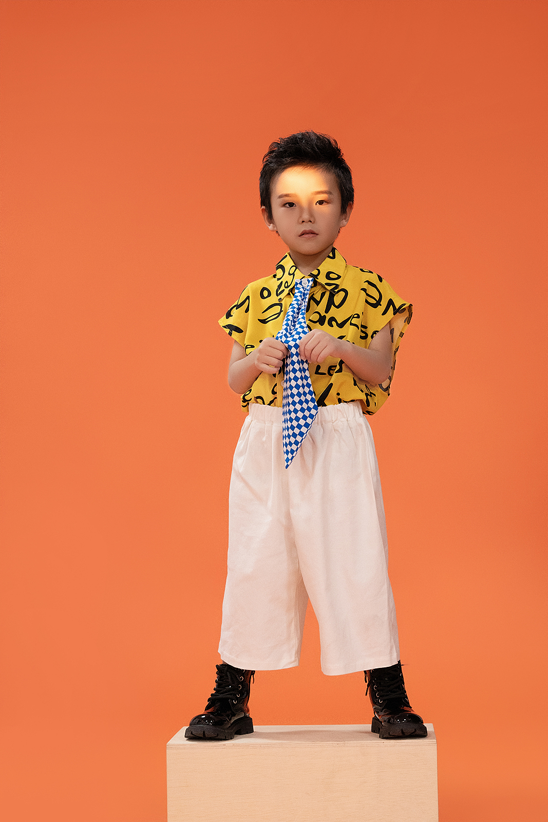 Boy in bow tie with classic portrait backdrop in Queens photography studio