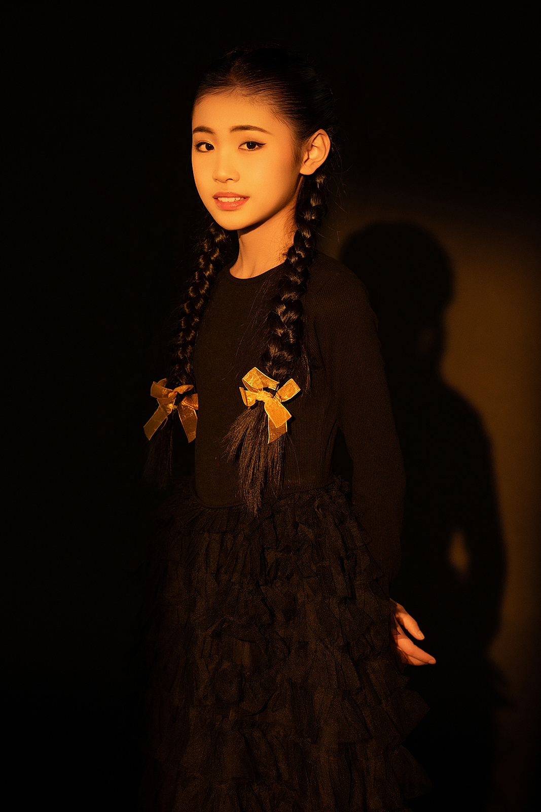 Smiling girl sitting on wooden stool during high-end studio photoshoot
