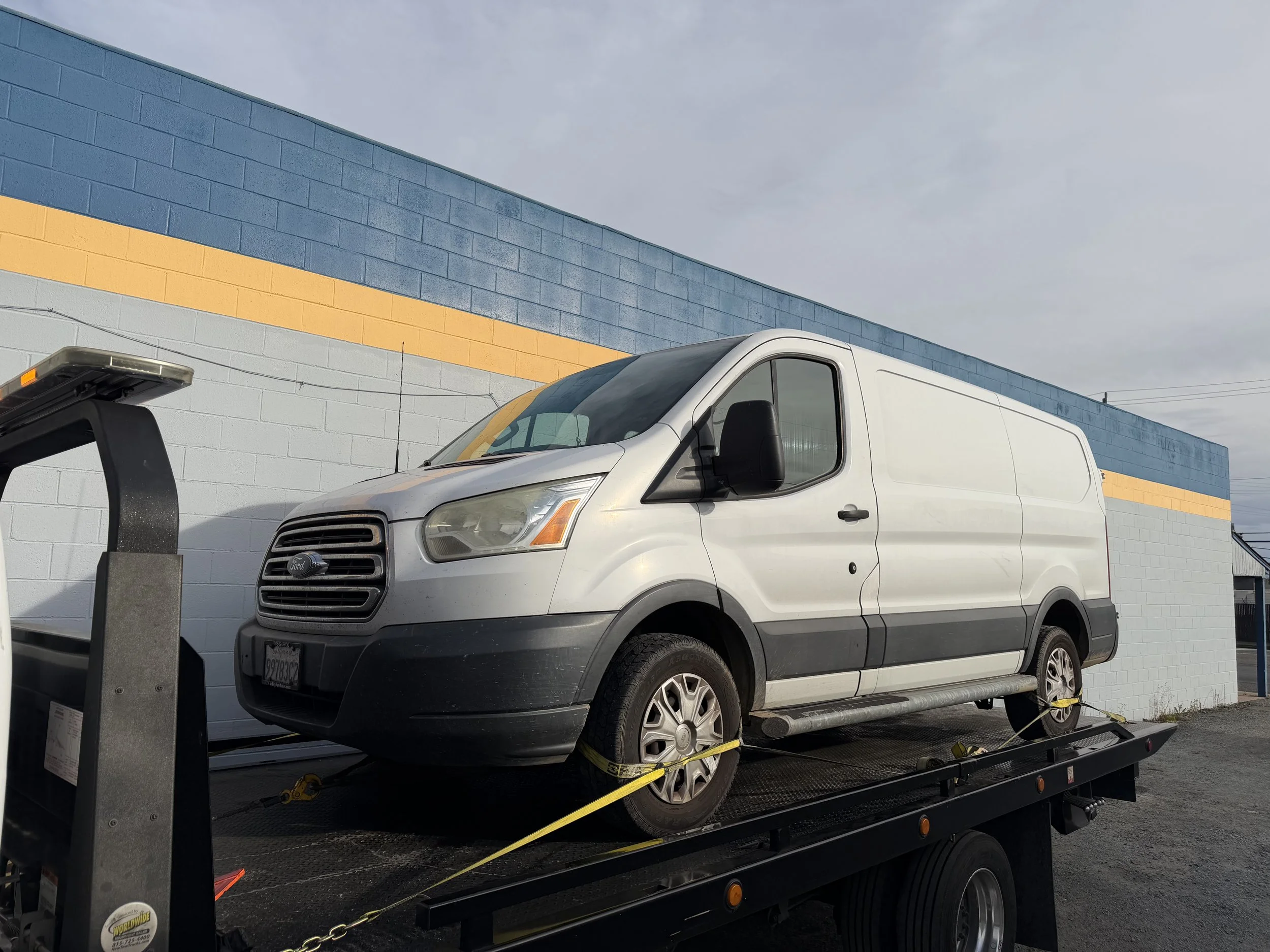 Rio Vista towing service transporting Ford Transit van on flatbed tow truck