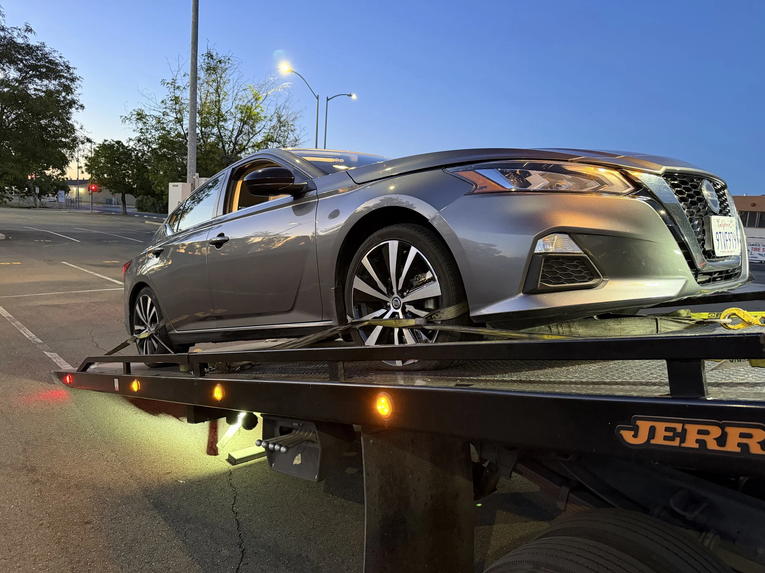 Sedan being loaded onto flatbed tow truck in Pittsburg California
