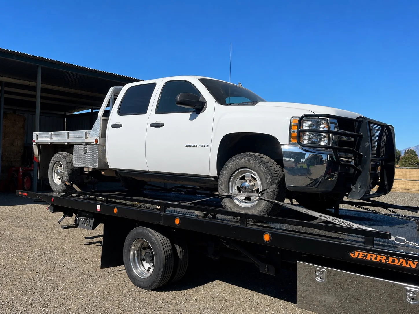 24-7 Rescue Towing transporting a Chevrolet 3500 truck on a flatbed tow truck in Discovery Bay, California