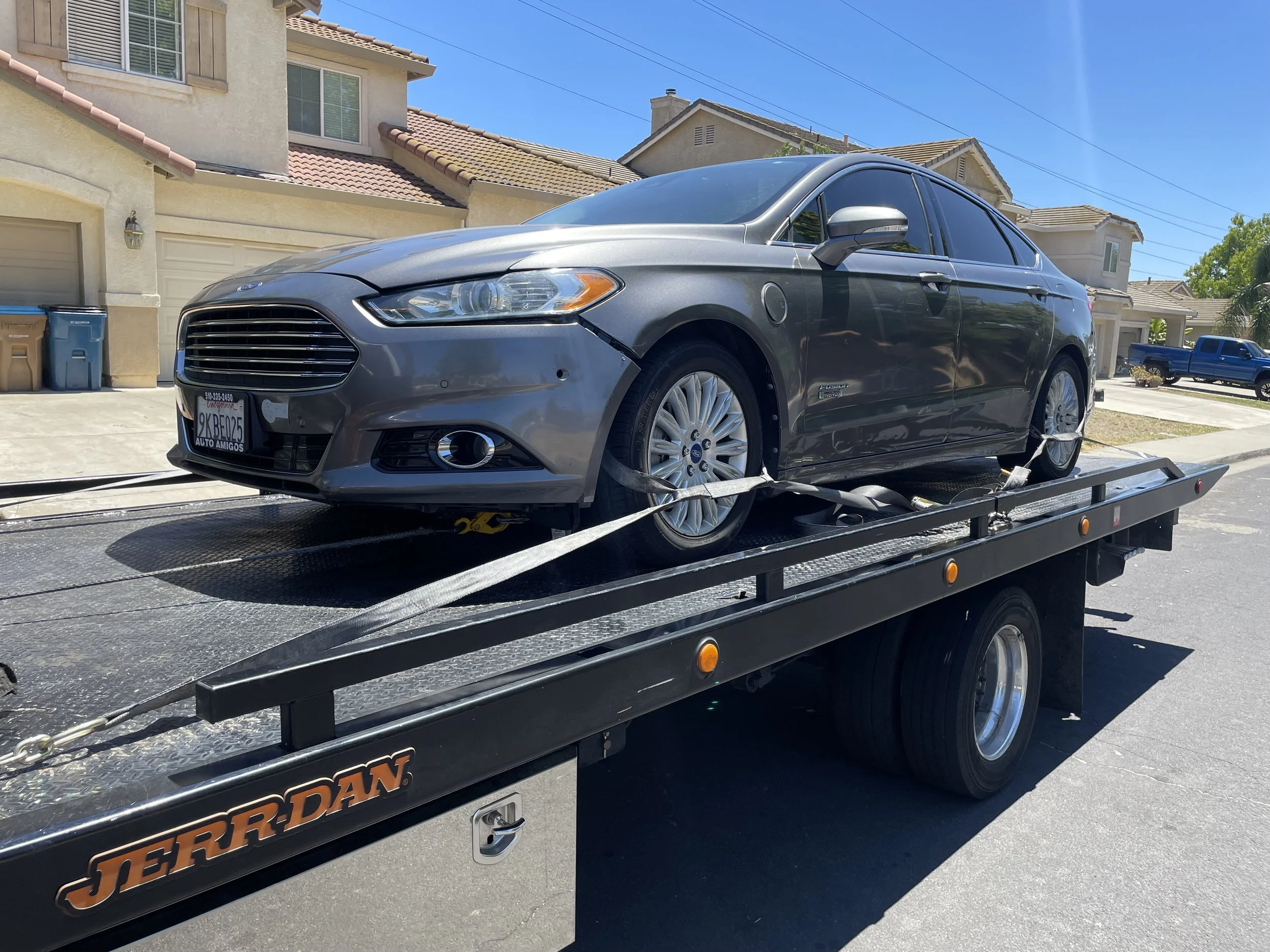 Ford Fusion Hybrid being transported on a flatbed tow truck in Antioch California by 24-7 Rescue Towing providing professional vehicle transport and roadside assistance.